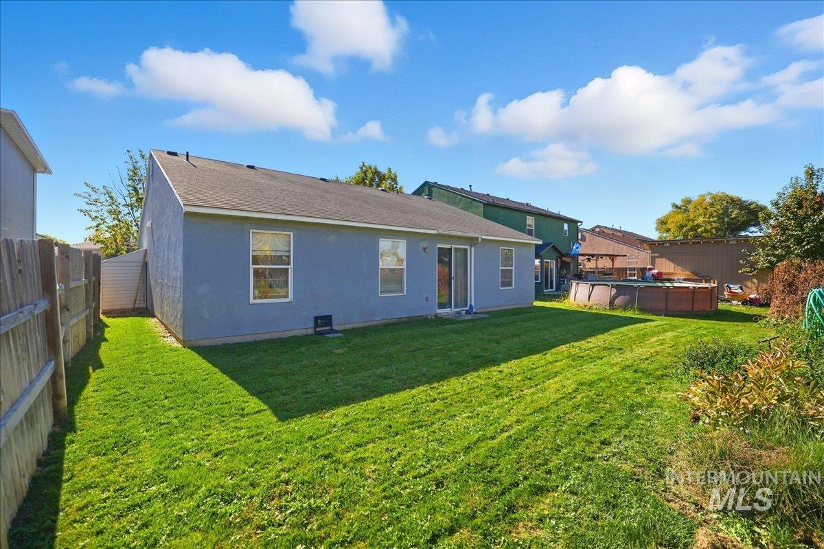 Rear view of property featuring a fenced backyard and stucco siding