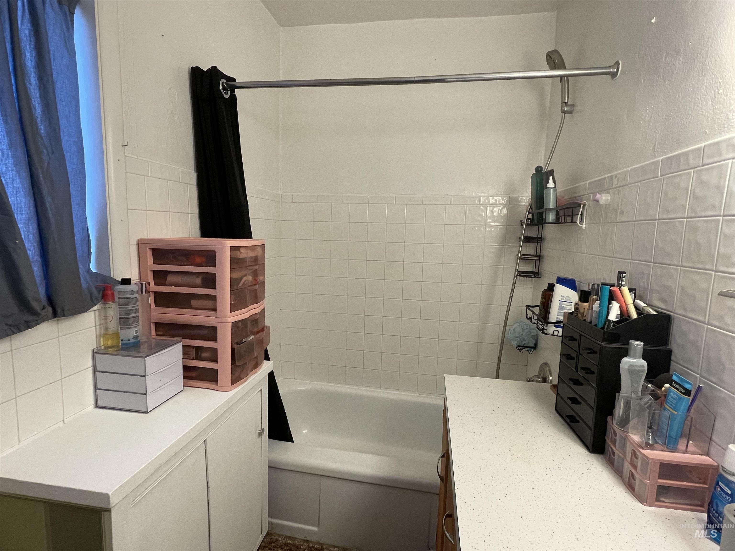 Full bath with shower / bath combination with curtain, tile walls, and vanity