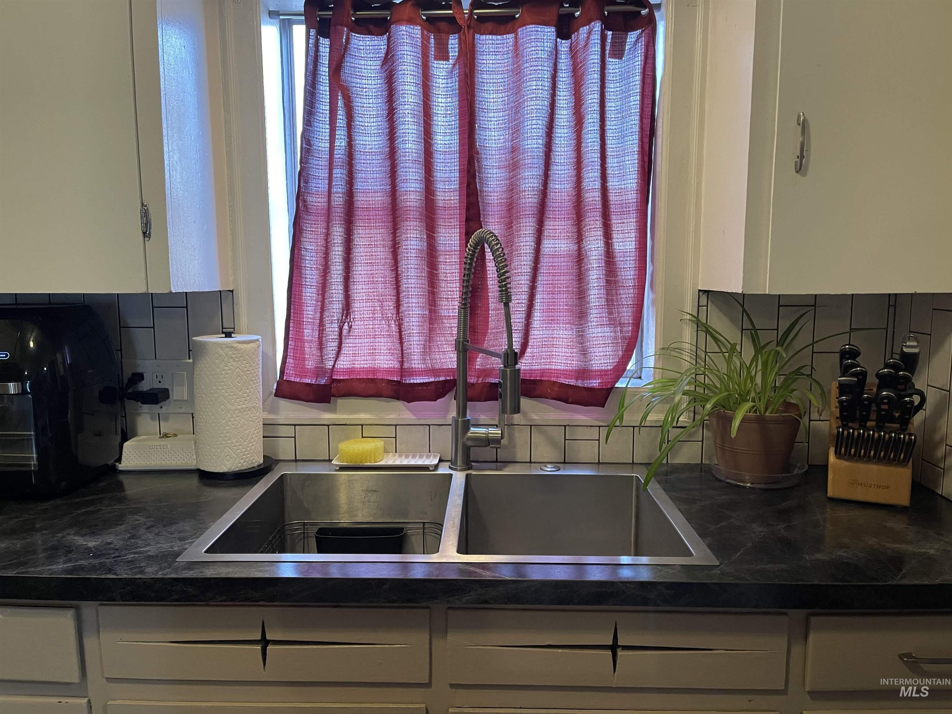 Kitchen with backsplash and white cabinetry