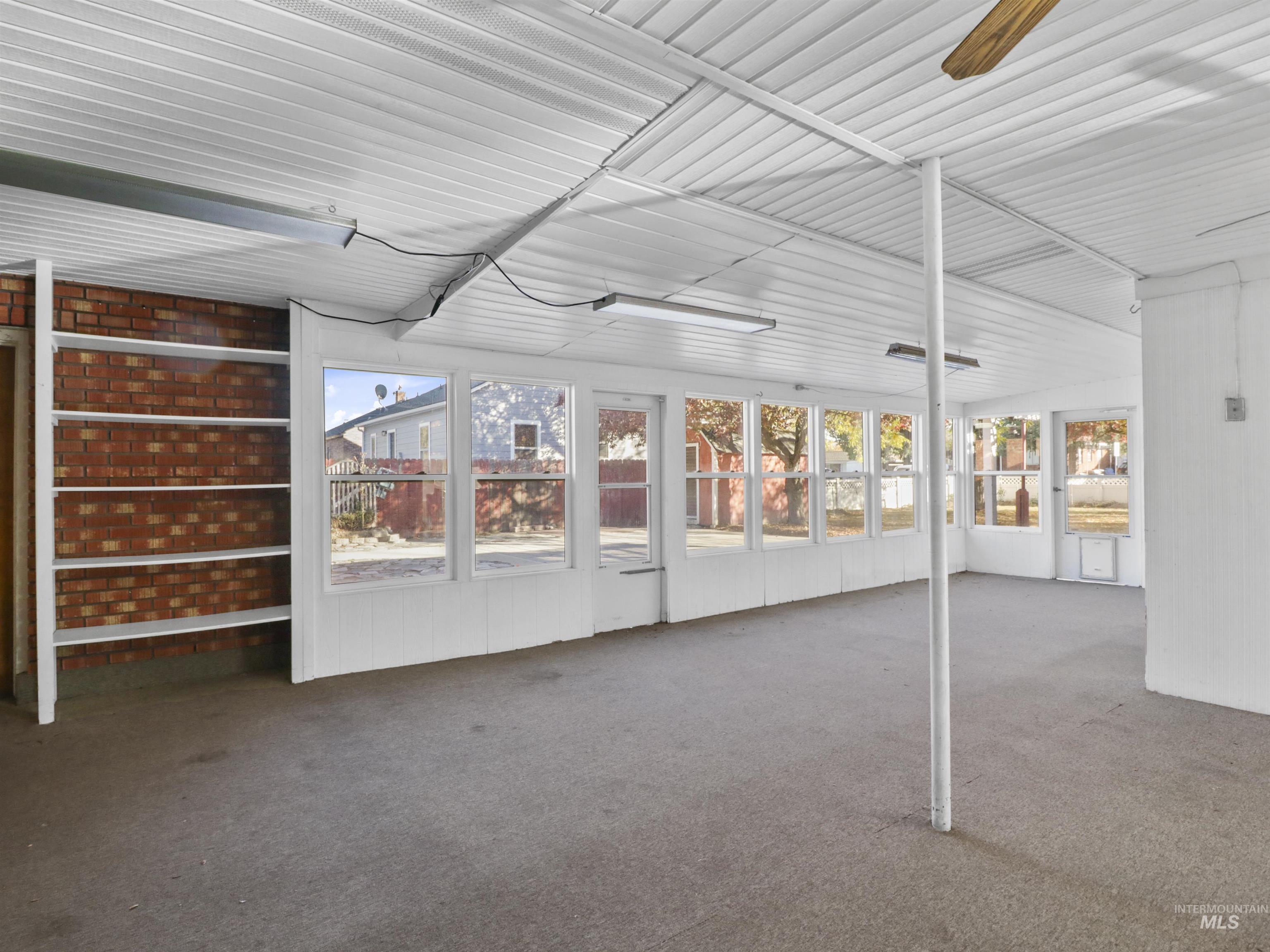 Unfurnished sunroom featuring ceiling fan