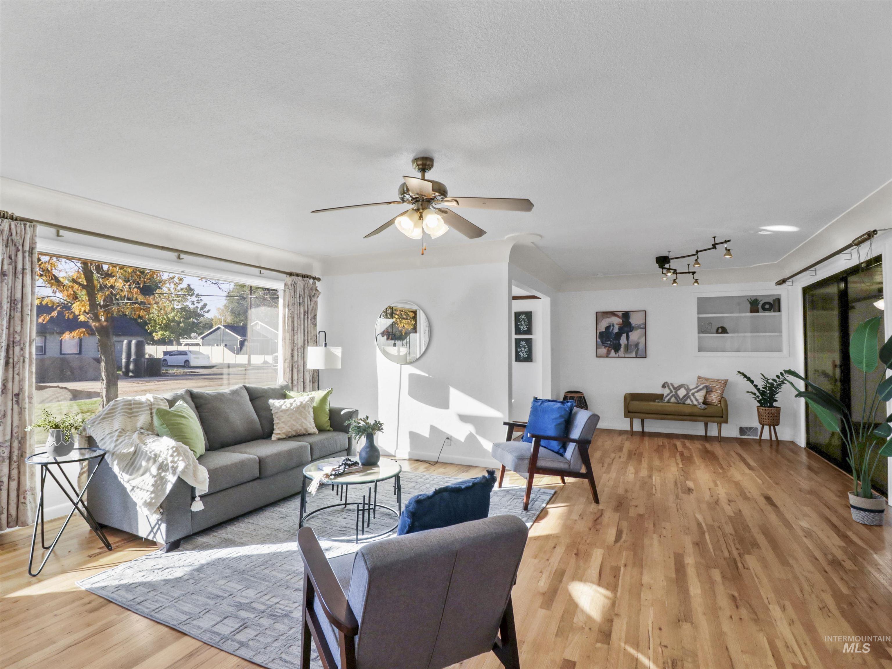 Living area featuring light wood-type flooring and ceiling fan