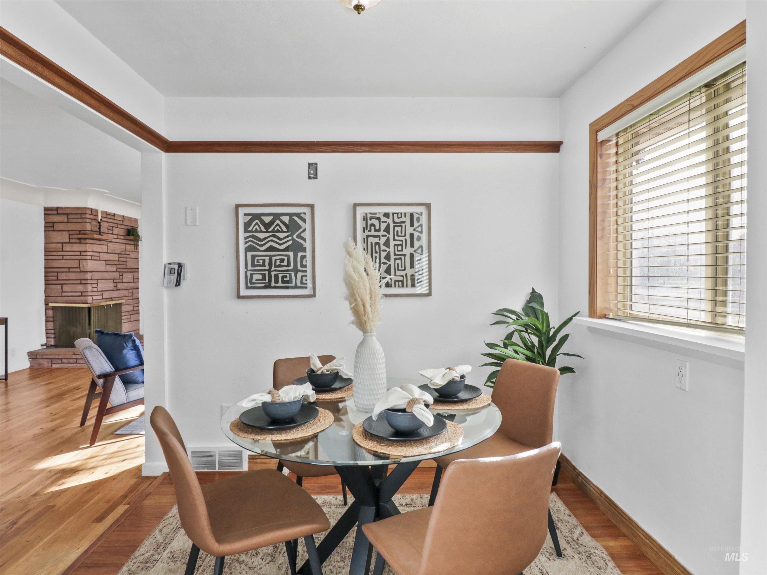 Dining area with wood finished floors and a fireplace