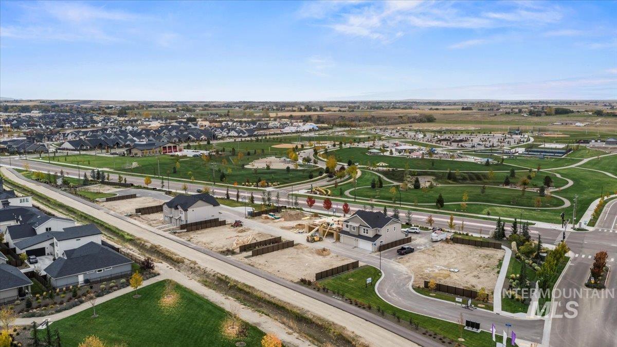 Aerial view of property and surrounding area featuring nearby suburban area