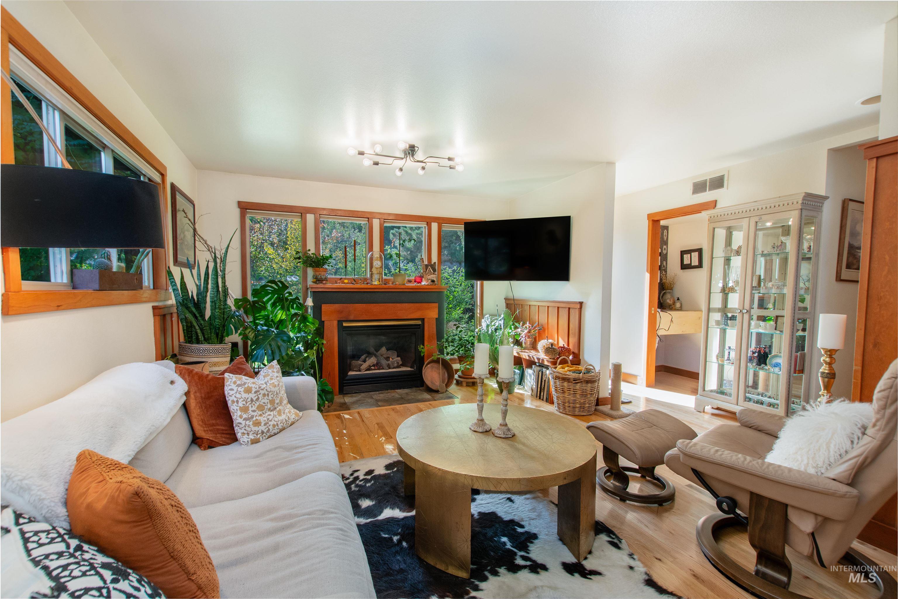Living room with a glass covered fireplace and wood finished floors