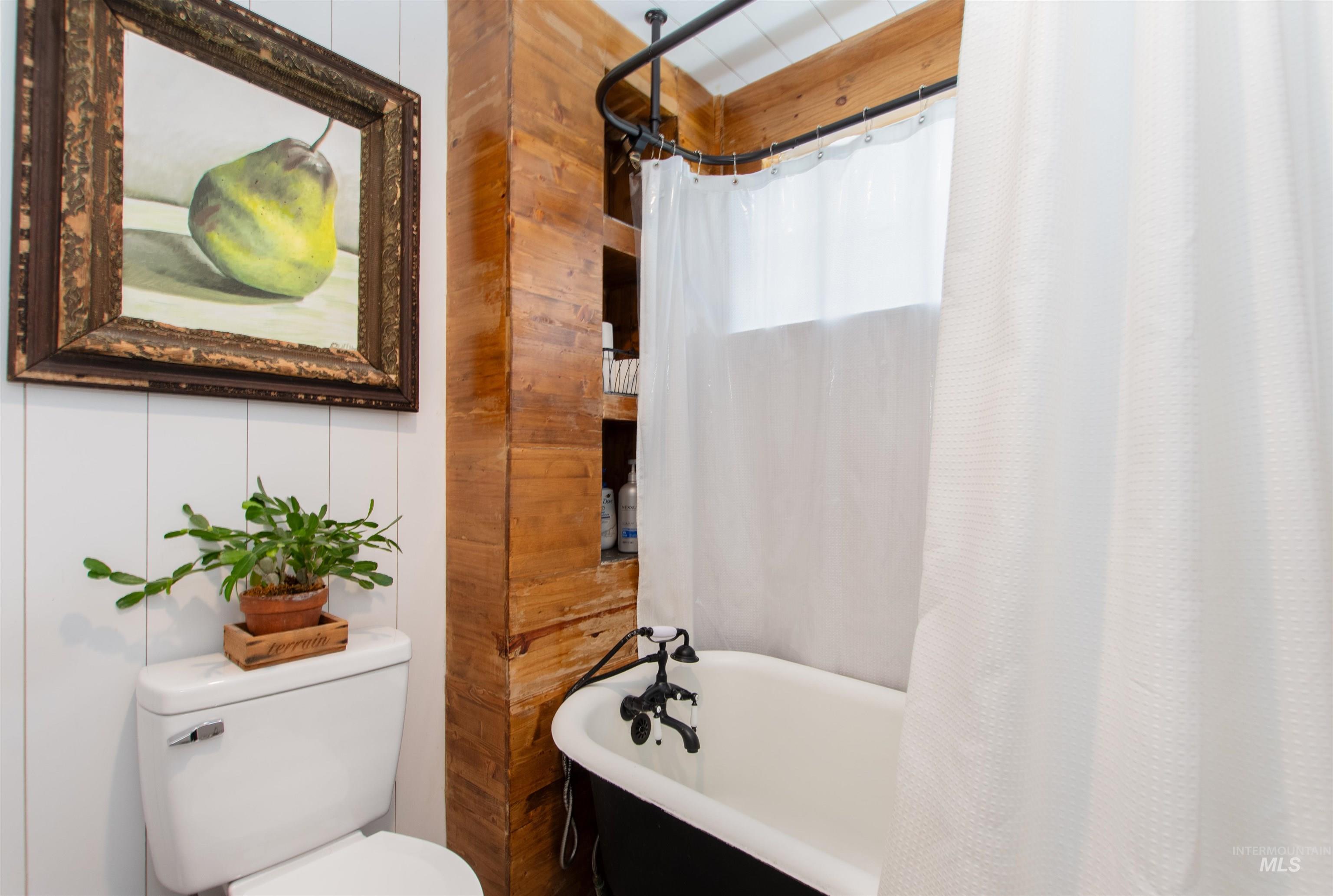 Bathroom with a freestanding tub and a shower with curtain