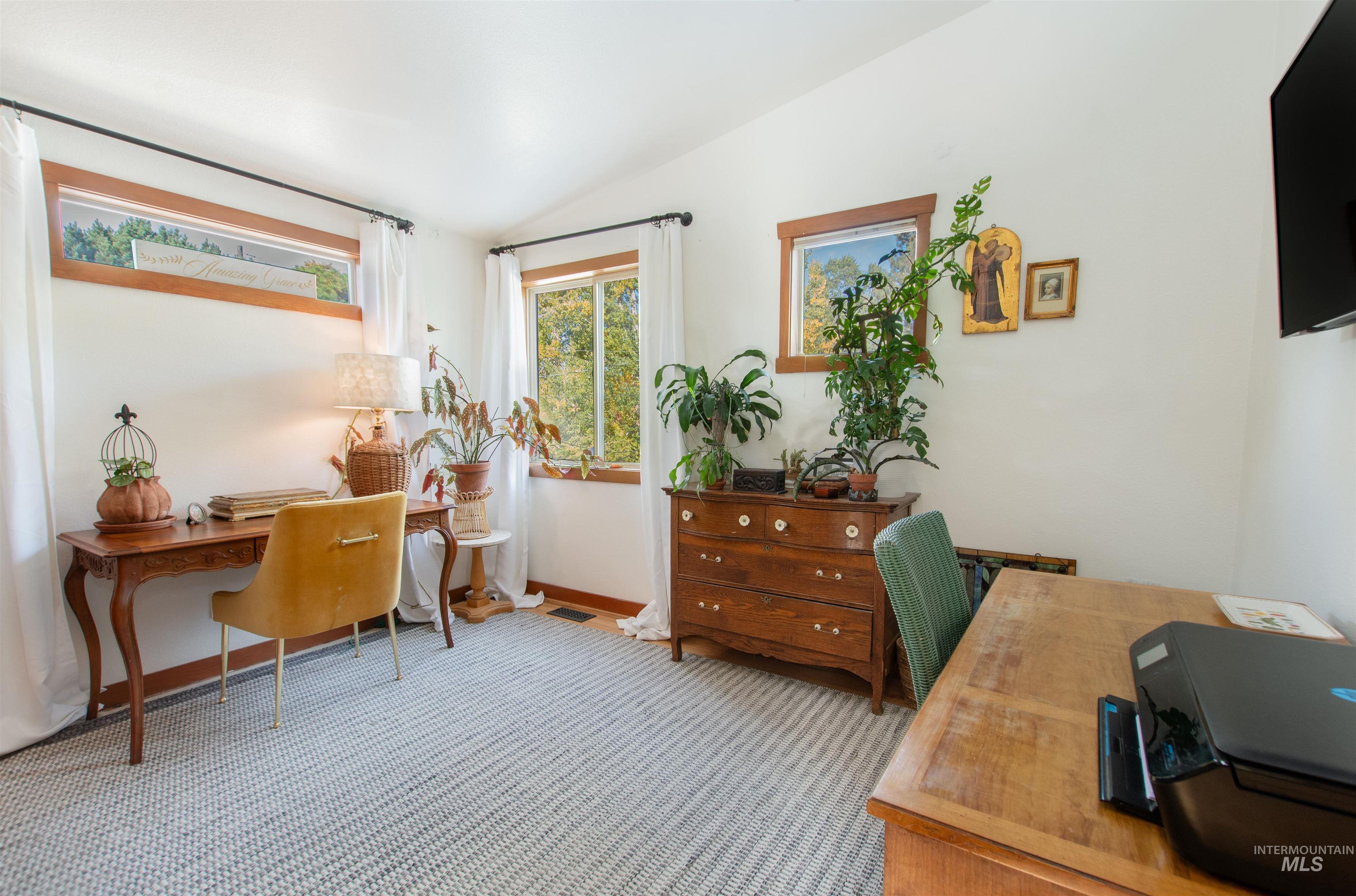 Office with vaulted ceiling and carpet flooring