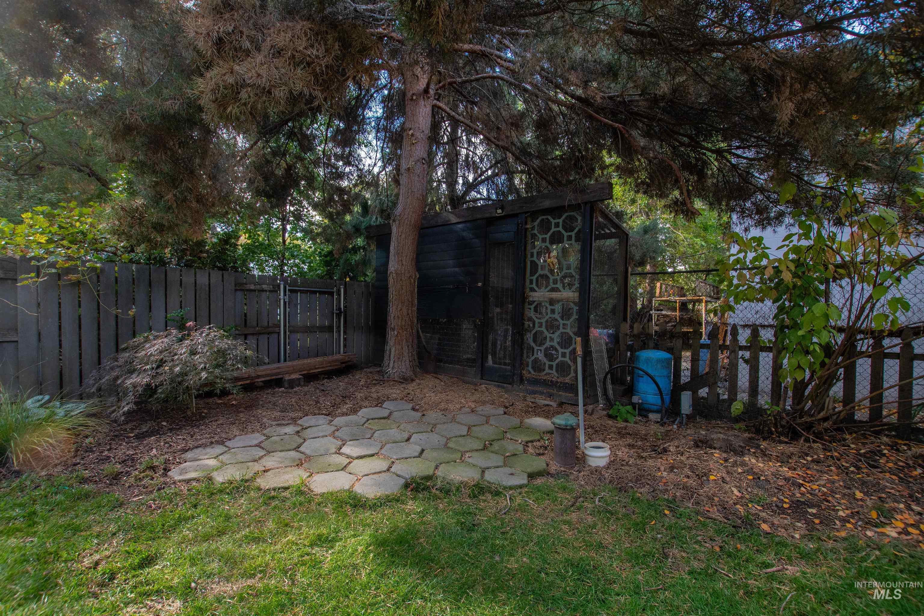 Fenced backyard with an outbuilding