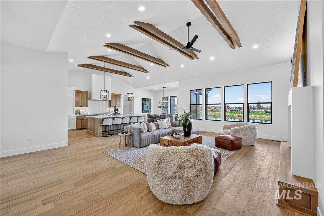 Living room with beam ceiling, light wood-type flooring, high vaulted ceiling, a ceiling fan, and recessed lighting