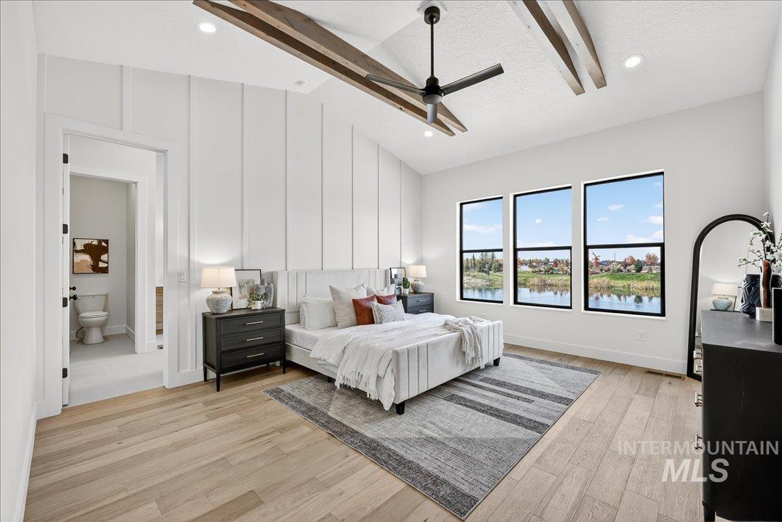 Bedroom with light wood-type flooring, a water view, recessed lighting, ceiling fan, and a textured ceiling