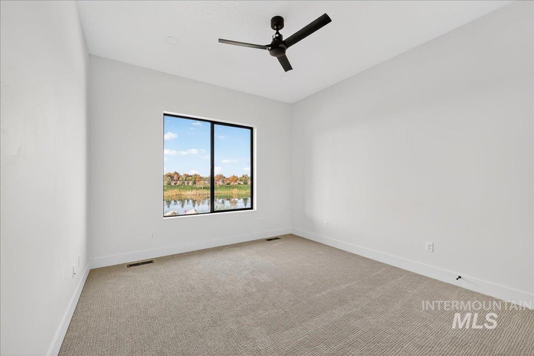 Unfurnished room with light colored carpet and a ceiling fan