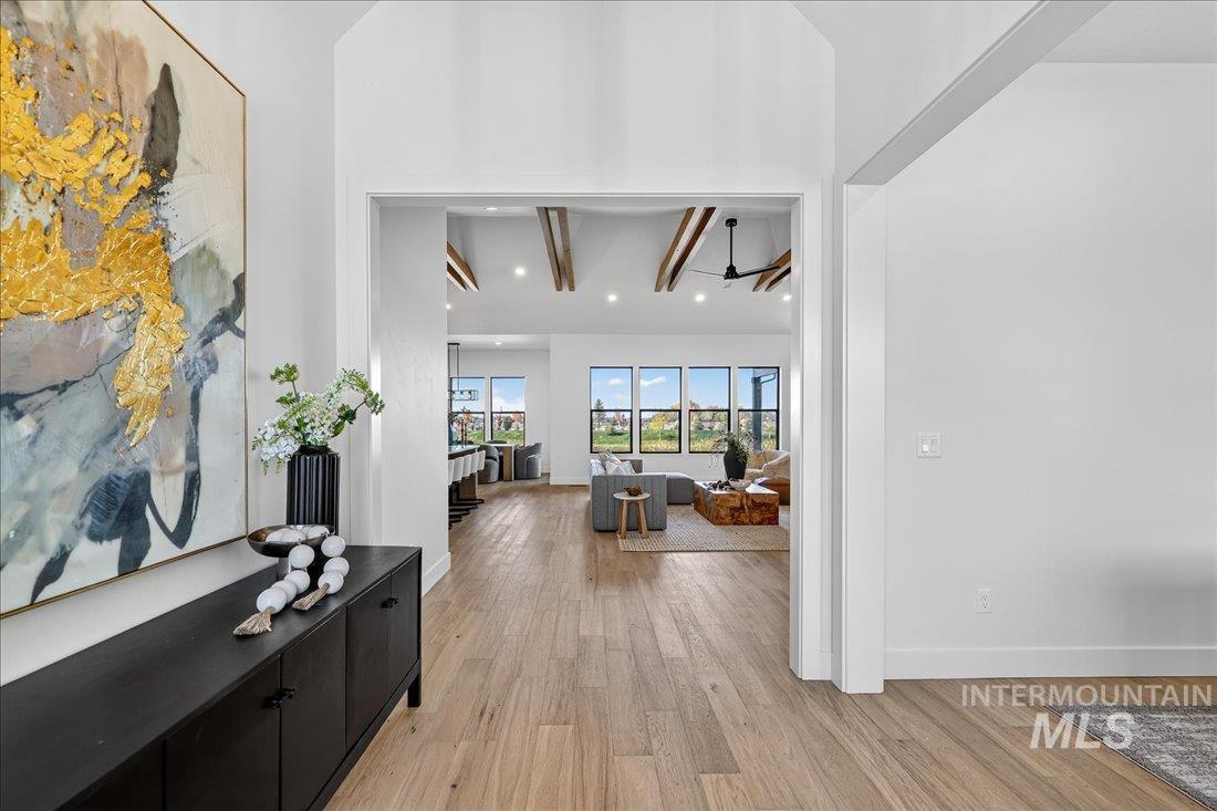 Corridor with light wood-style flooring, recessed lighting, and beam ceiling
