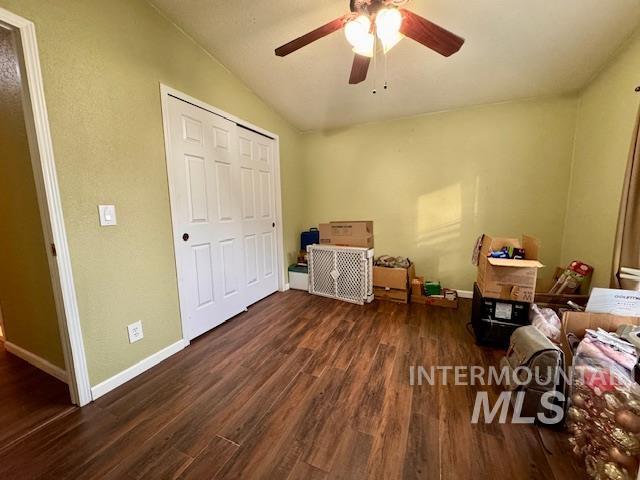 Bedroom featuring dark wood-type flooring, a closet, and a ceiling fan