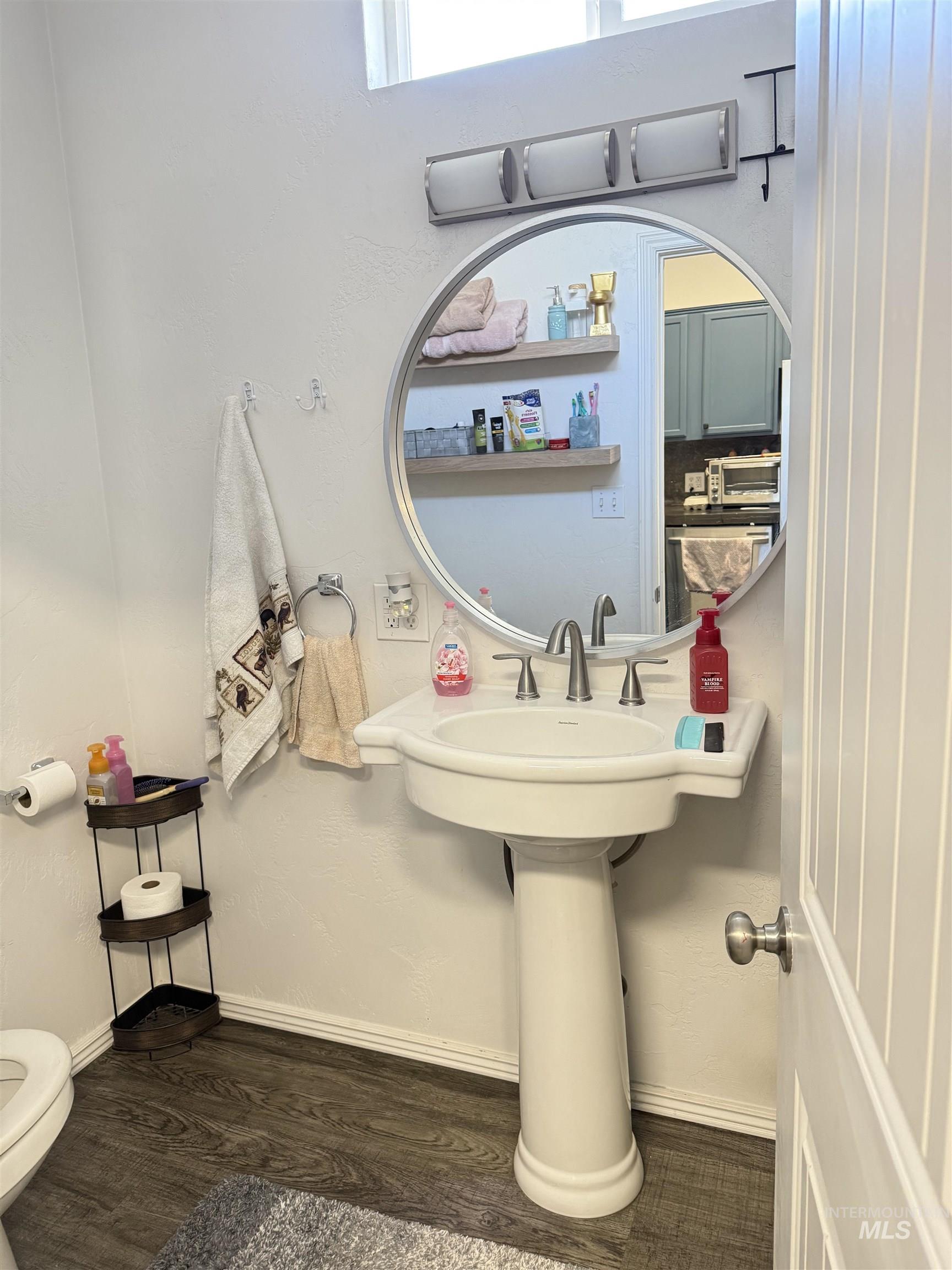 Bathroom featuring dark wood-type flooring, toilet and tub/shower