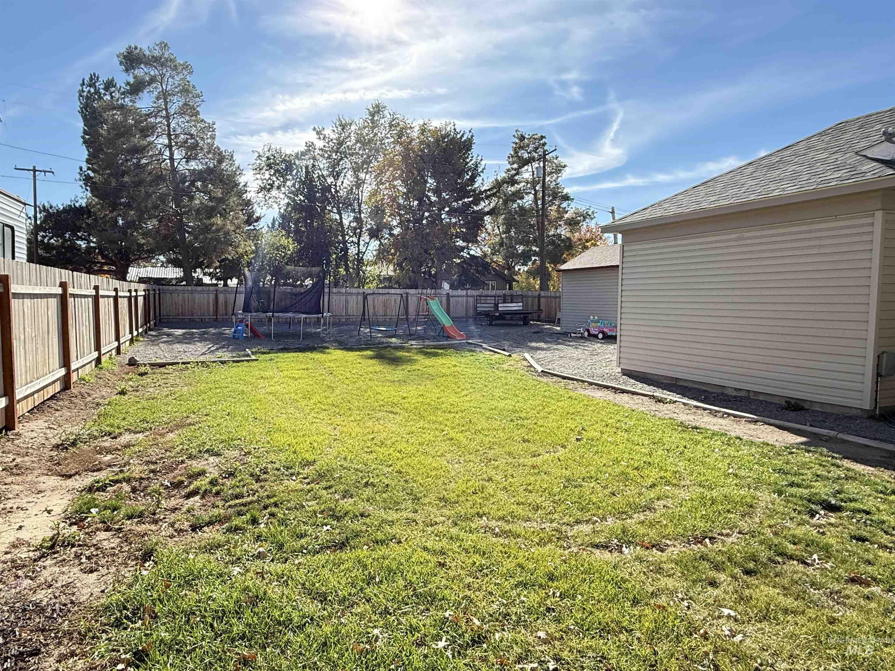 Fenced backyard with a patio and a trampoline