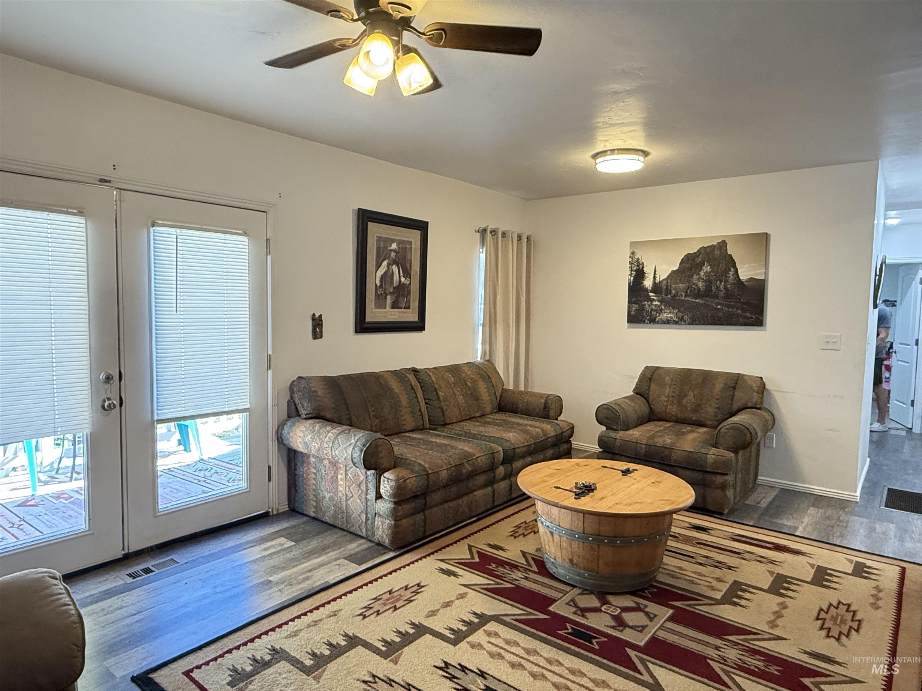 Living area featuring wood finished floors, french doors, and ceiling fan