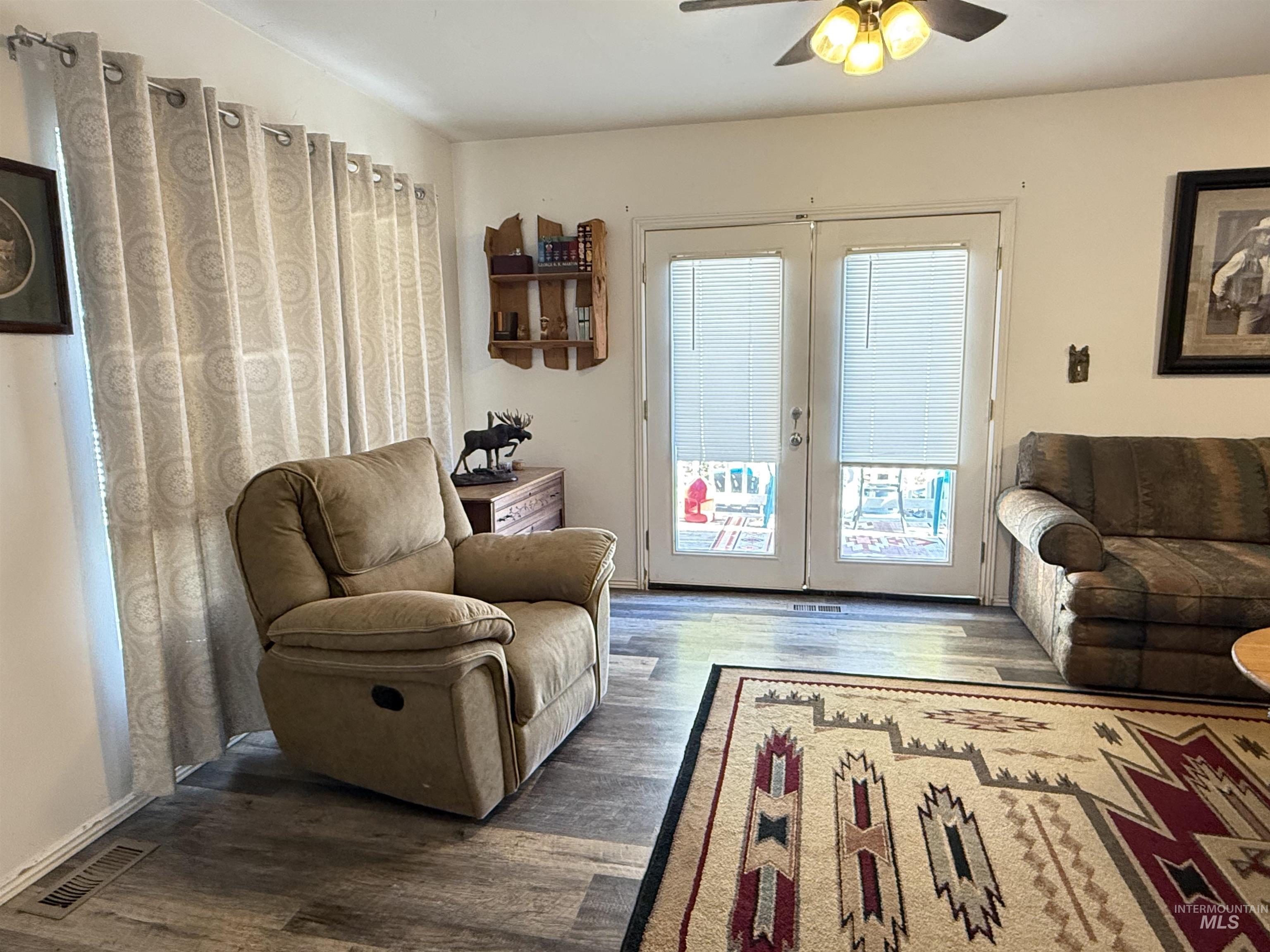 Living room featuring wood finished floors, french doors, and a ceiling fan
