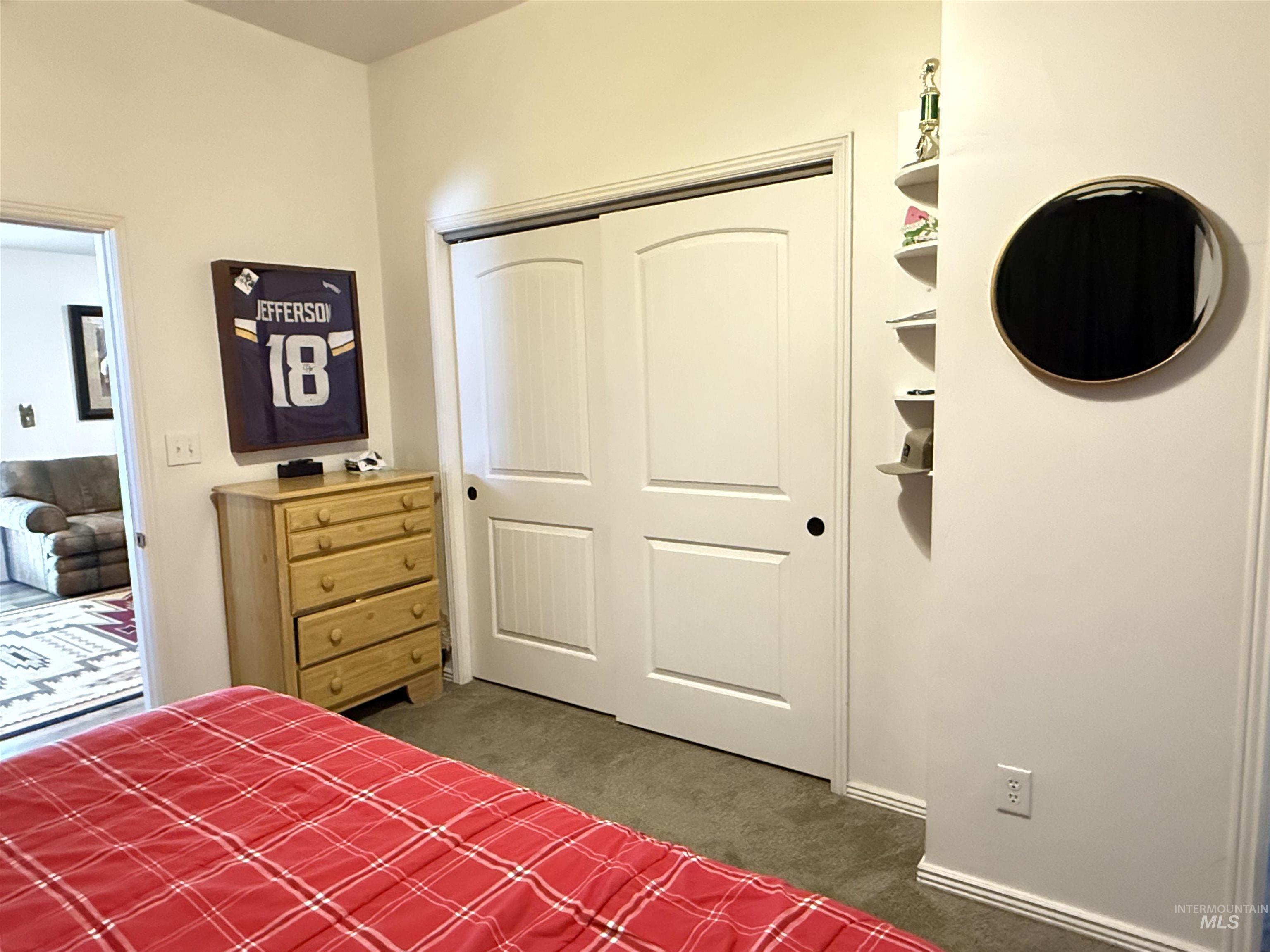 Bedroom featuring dark colored carpet and a closet