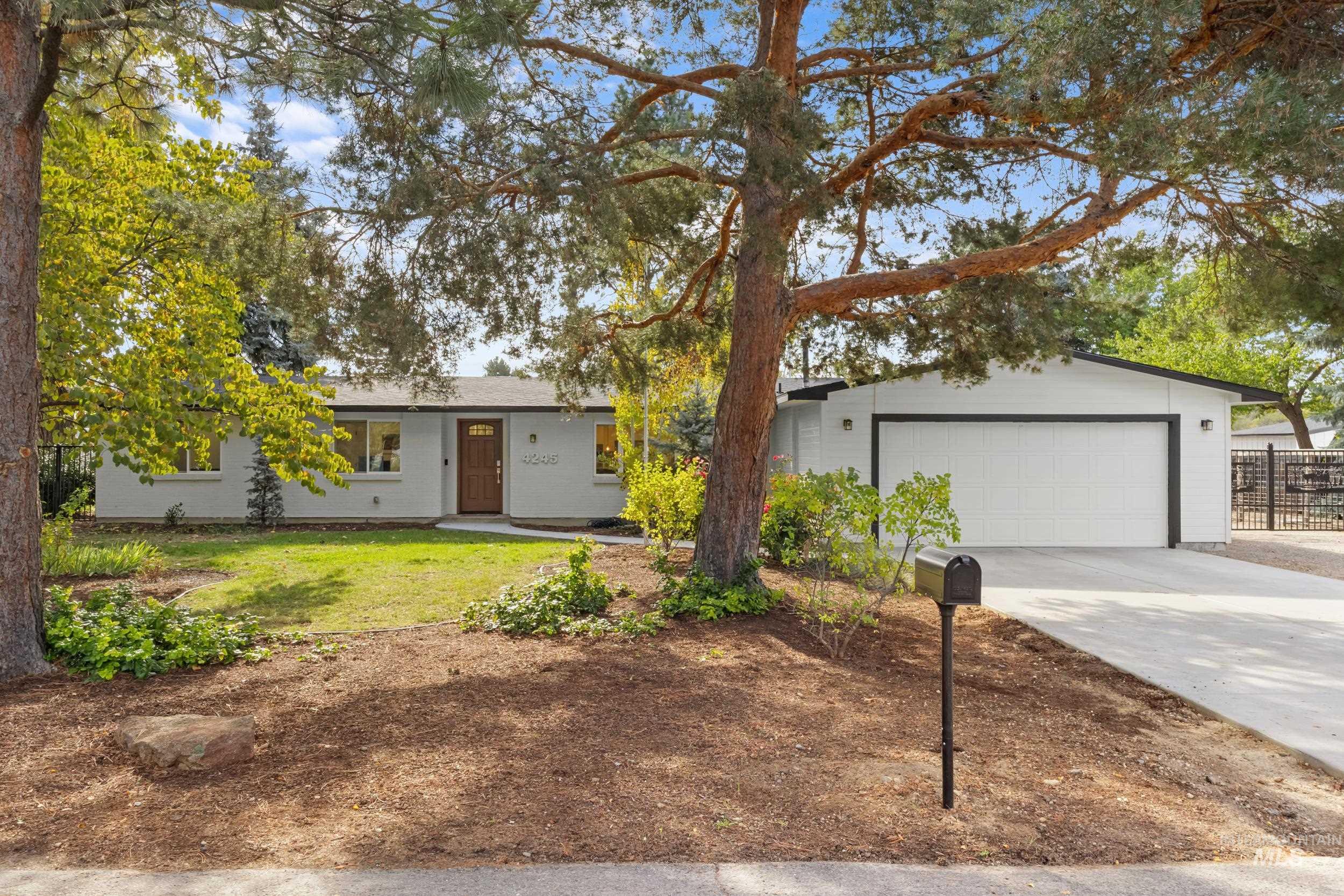 Ranch-style house with driveway, a front lawn, and an attached garage