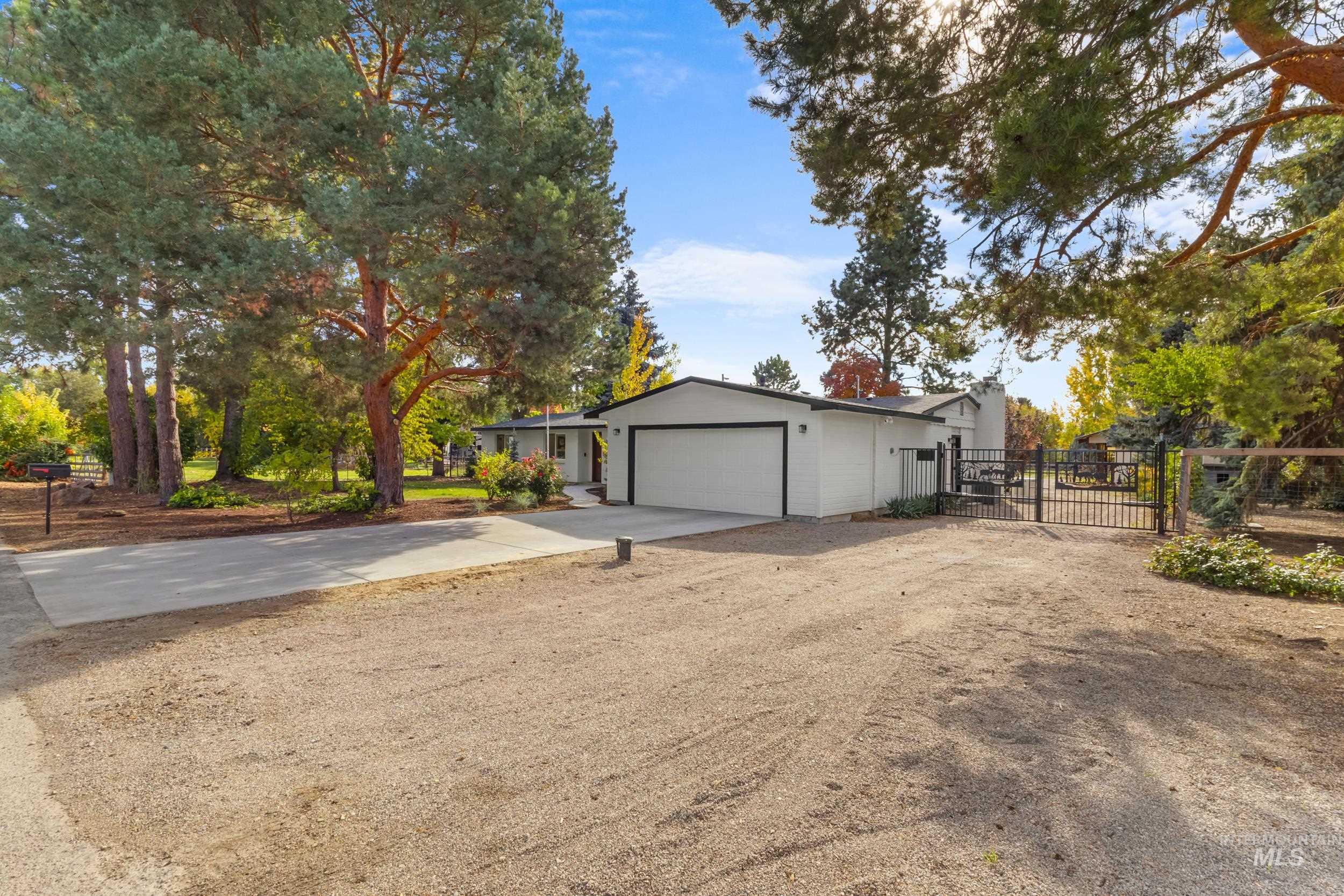 View of property exterior featuring concrete driveway, a gate, and a garage