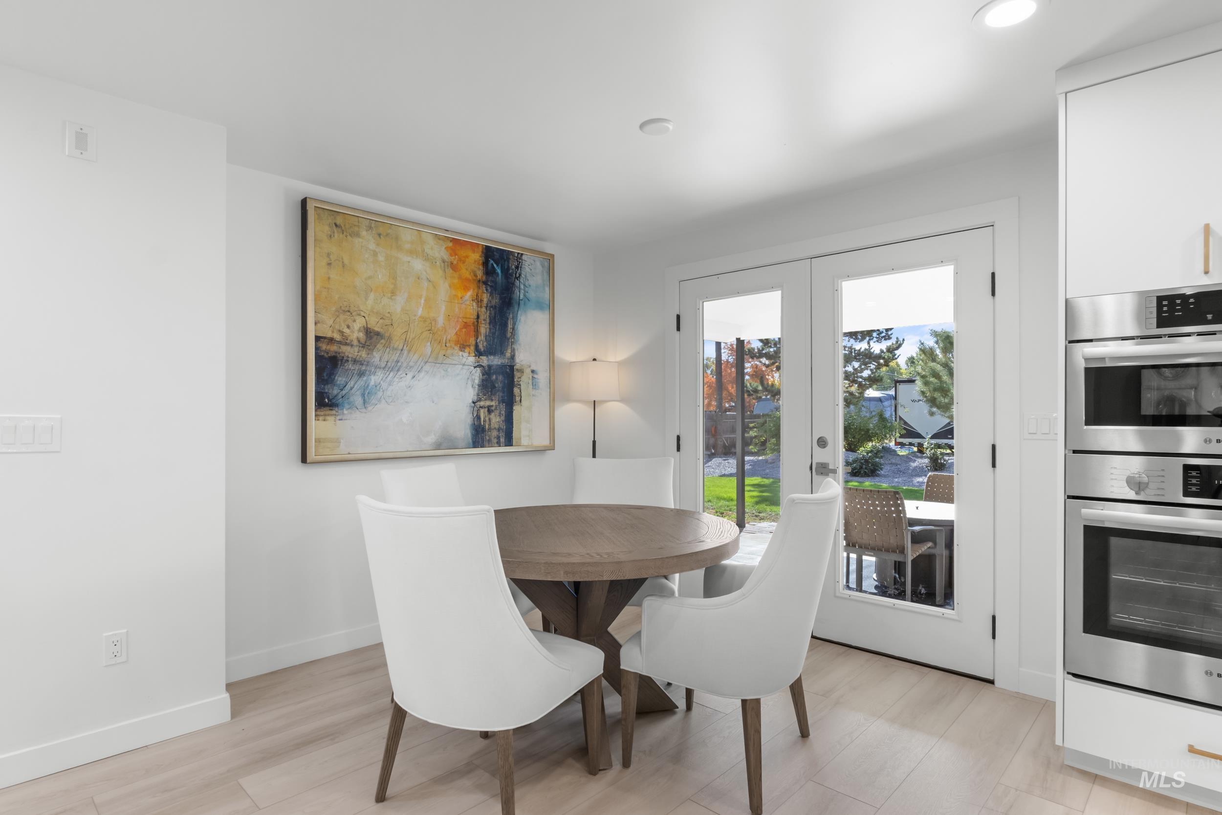 Dining area featuring french doors, light wood-type flooring, and recessed lighting