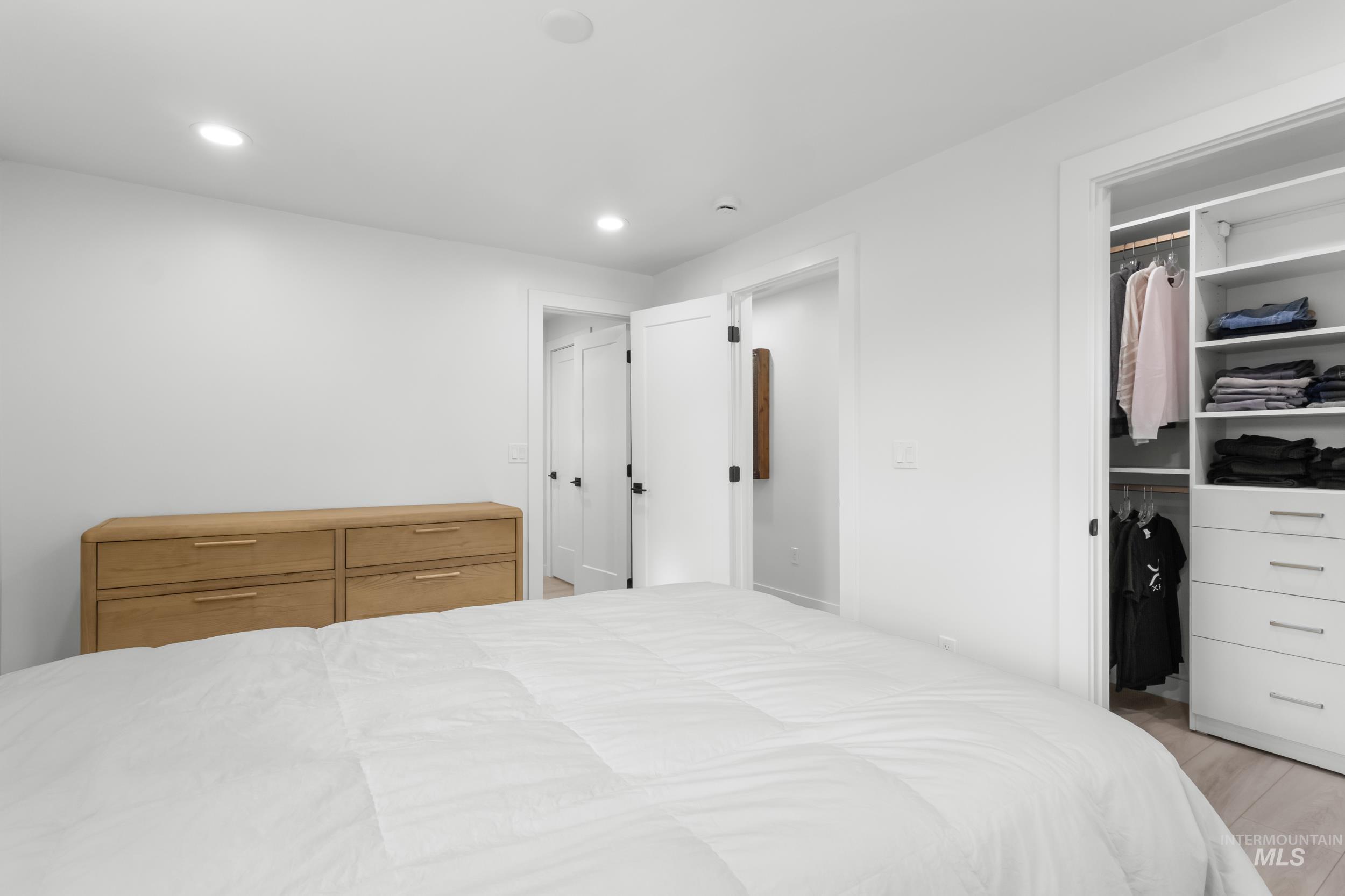 Bedroom featuring a walk in closet, recessed lighting, and wood finished floors