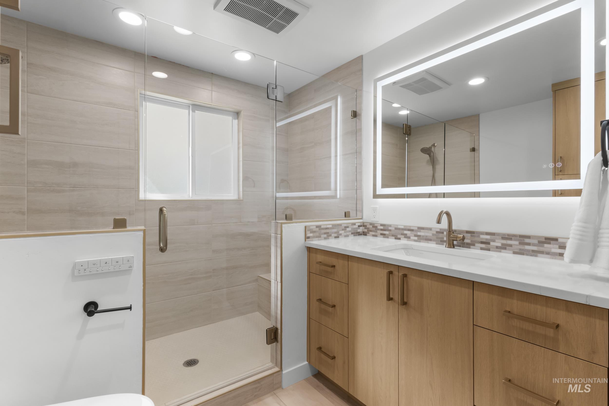 Full bath with vanity, decorative backsplash, a stall shower, and recessed lighting