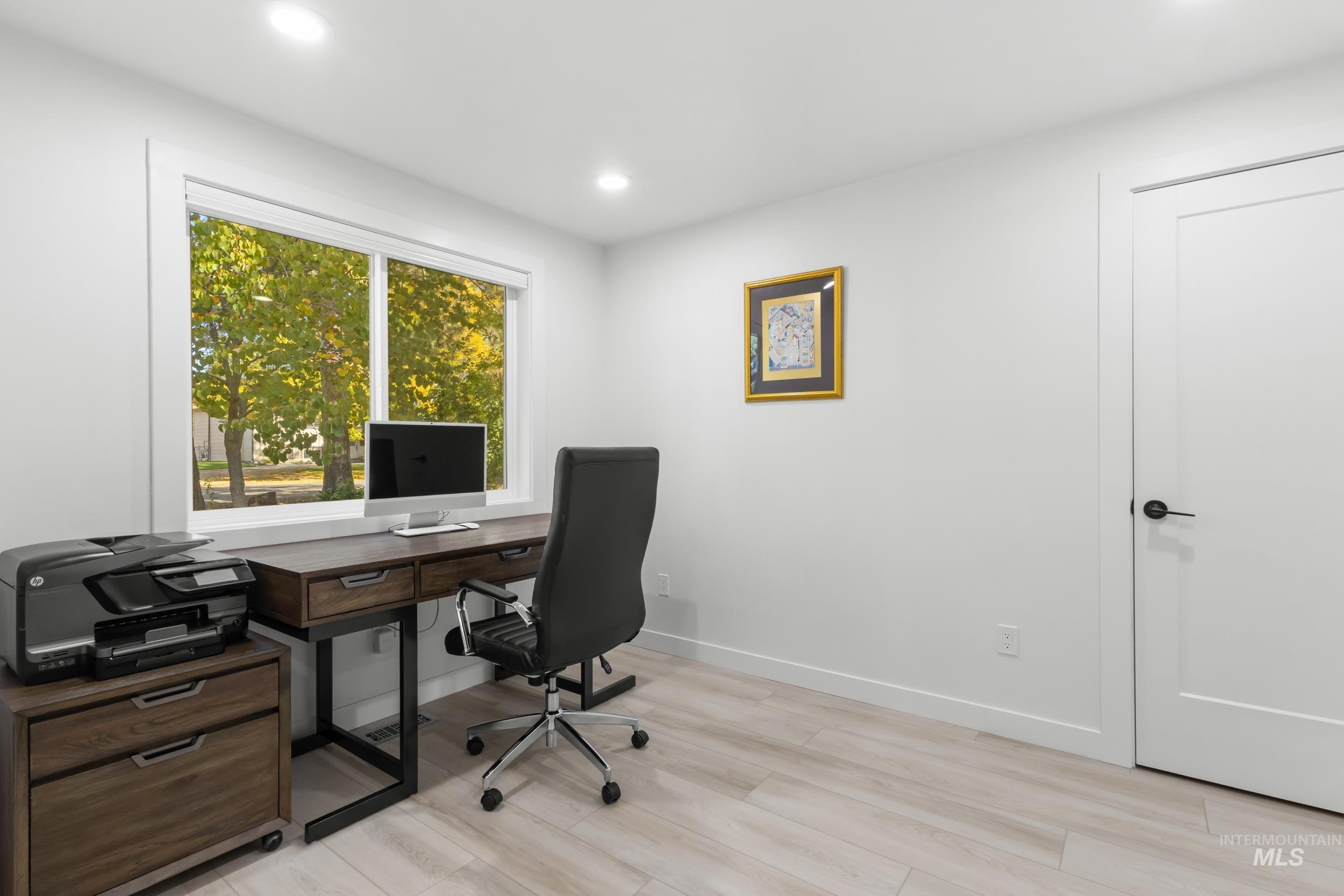 Office area with recessed lighting and light wood-style floors