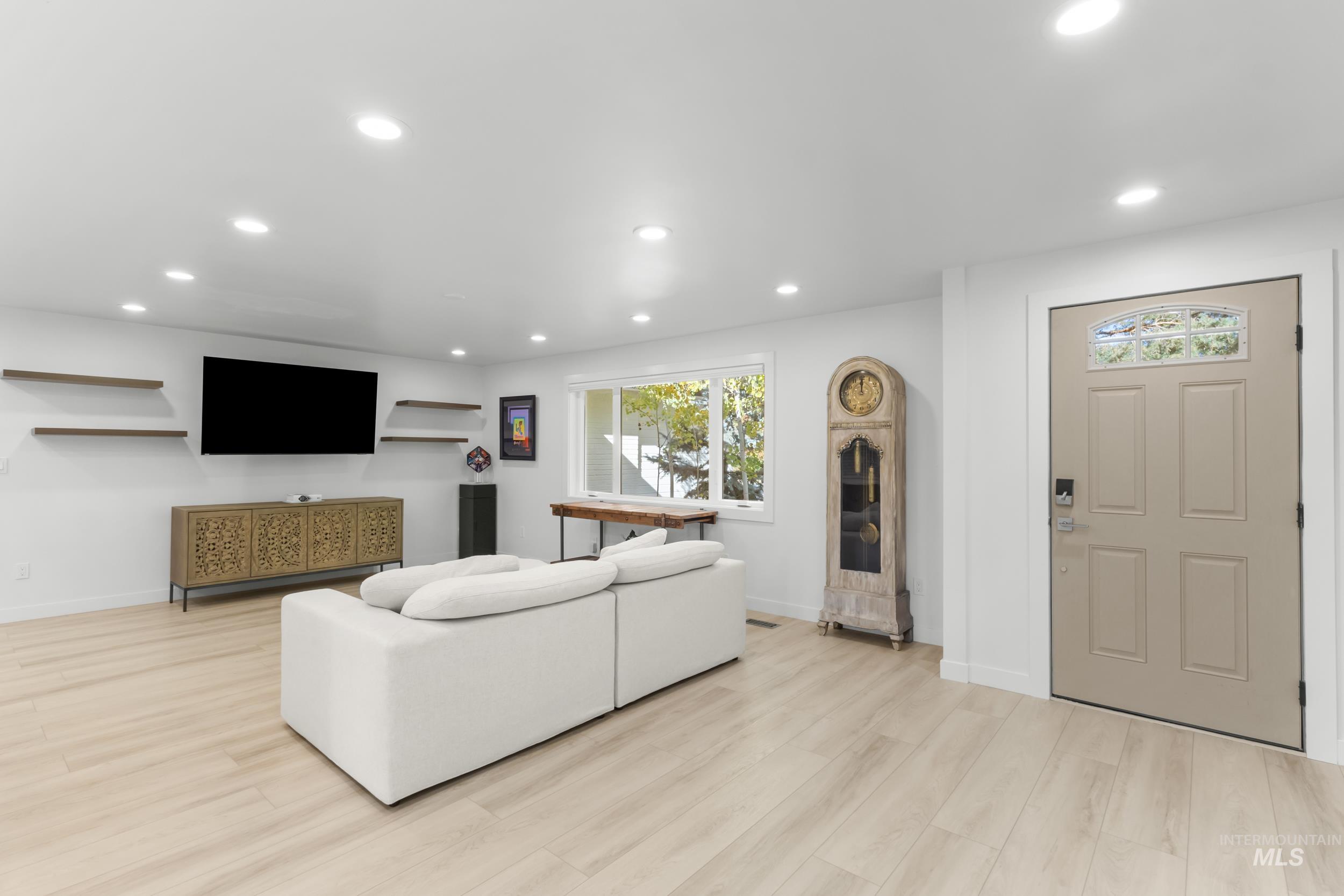 Living area with recessed lighting and light wood-type flooring