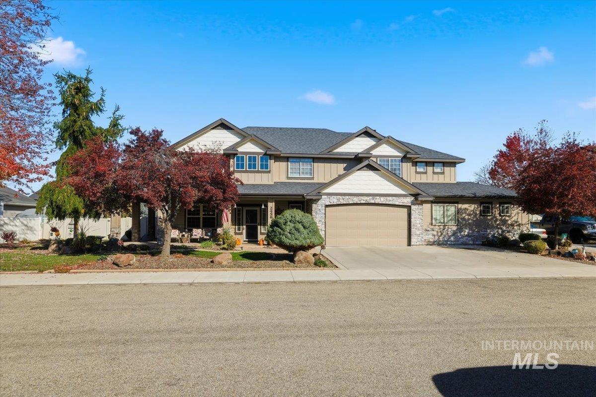 Craftsman house with covered porch, driveway, board and batten siding, and stone siding