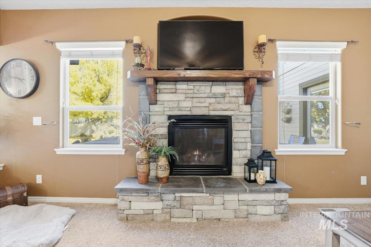 Detailed view of carpet floors and a stone fireplace