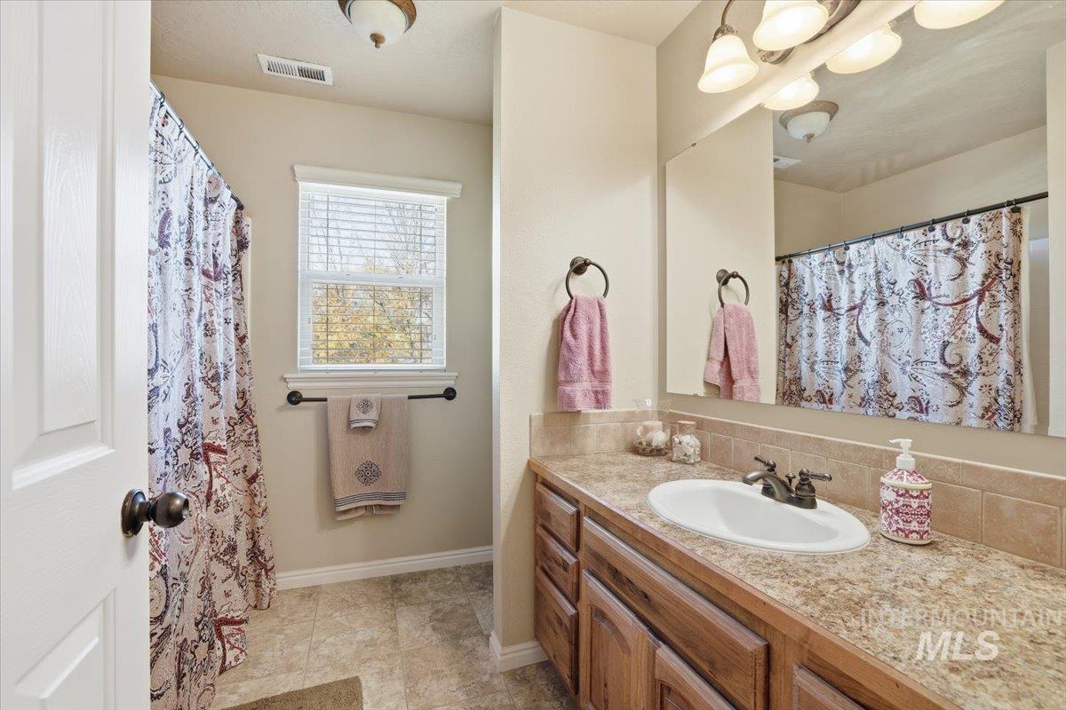 Full bath with vanity, a shower with curtain, and light tile patterned floors