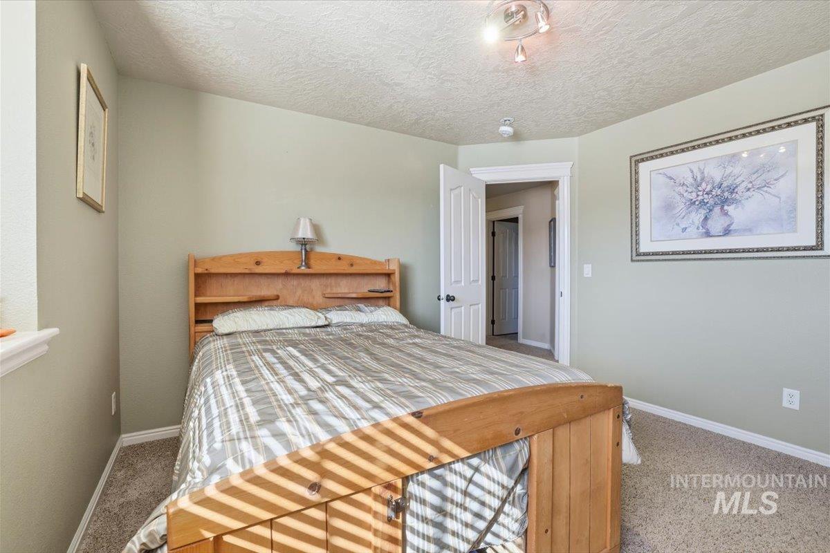 Bedroom featuring carpet flooring and a textured ceiling