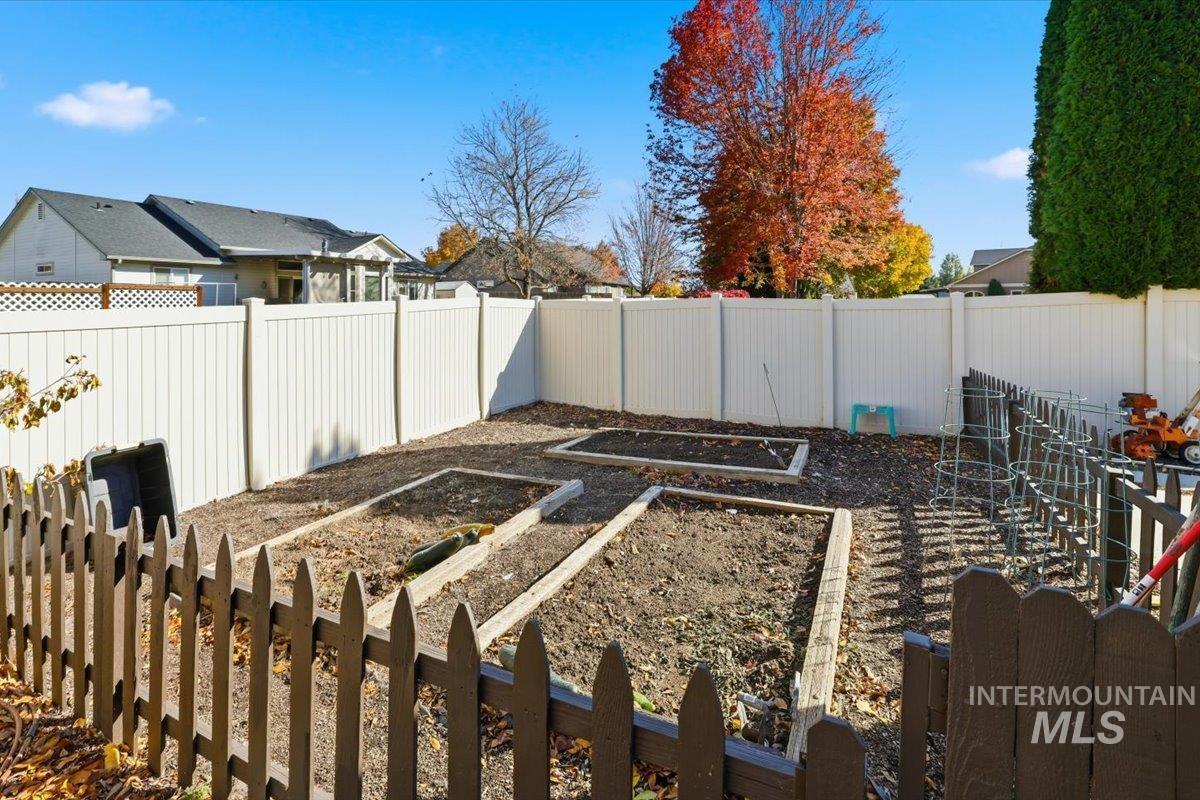 Fenced backyard featuring a garden