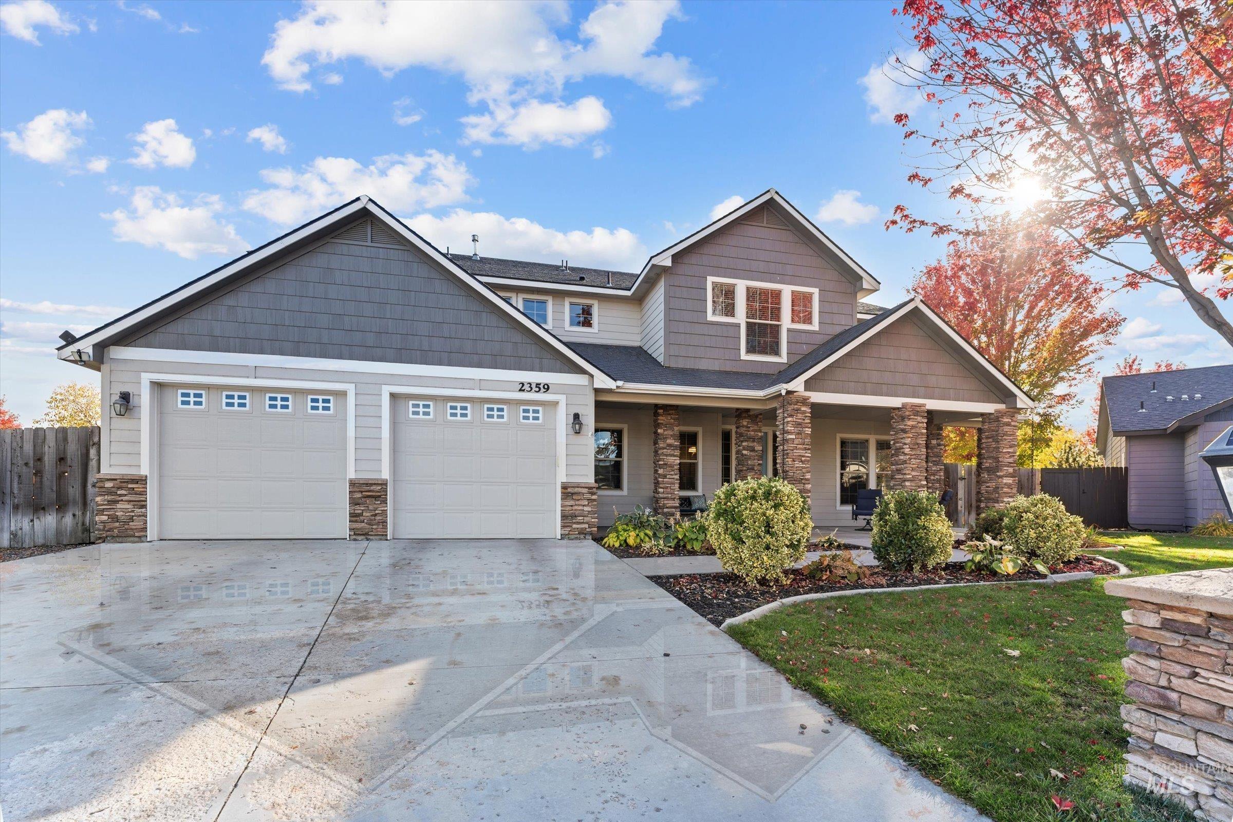 Craftsman house featuring covered porch, stone siding, concrete driveway, and a garage