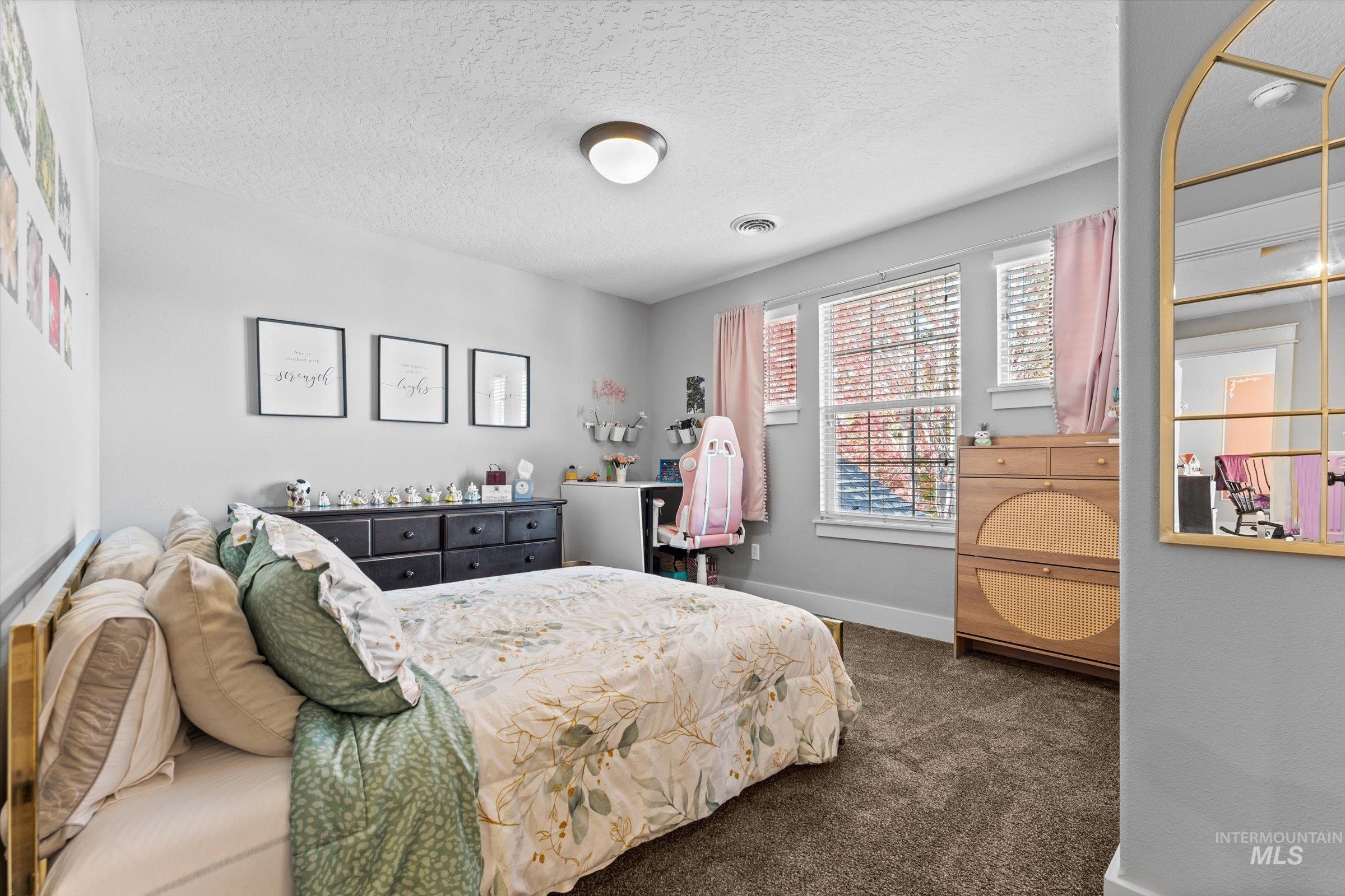Bedroom featuring a textured ceiling and dark carpet