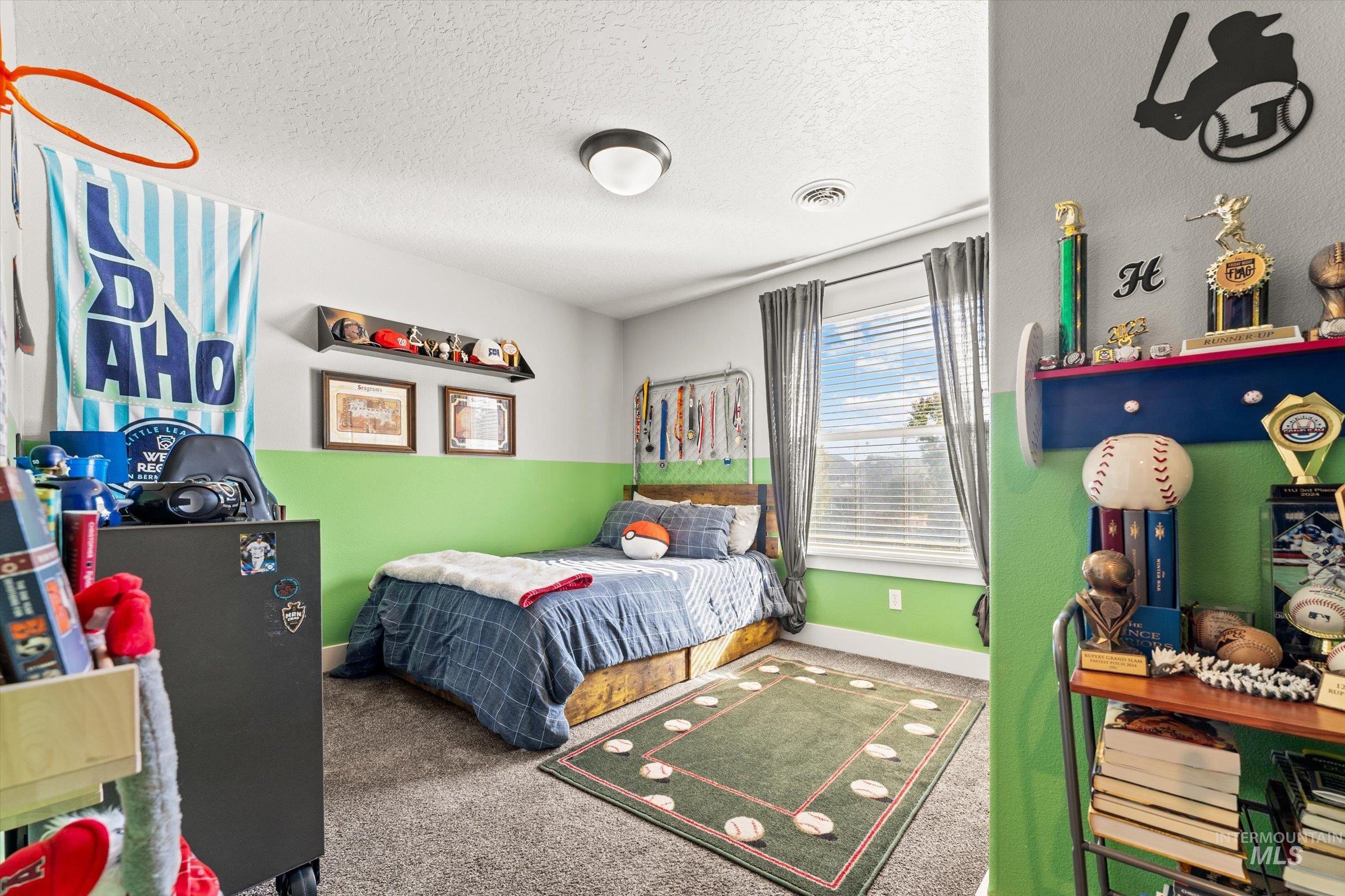 Bedroom with a textured ceiling and carpet floors