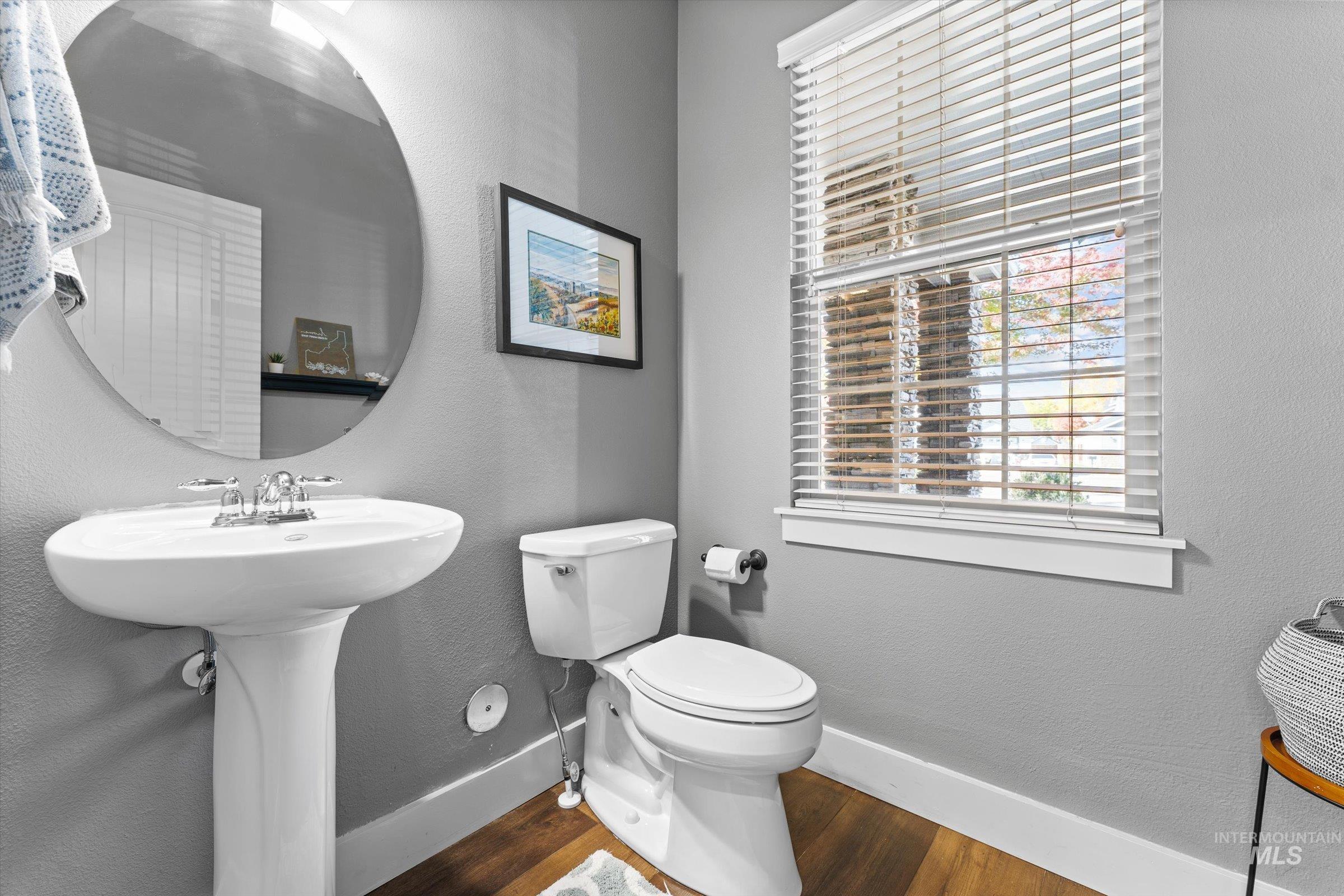 Half bathroom featuring a textured wall and dark wood-type flooring
