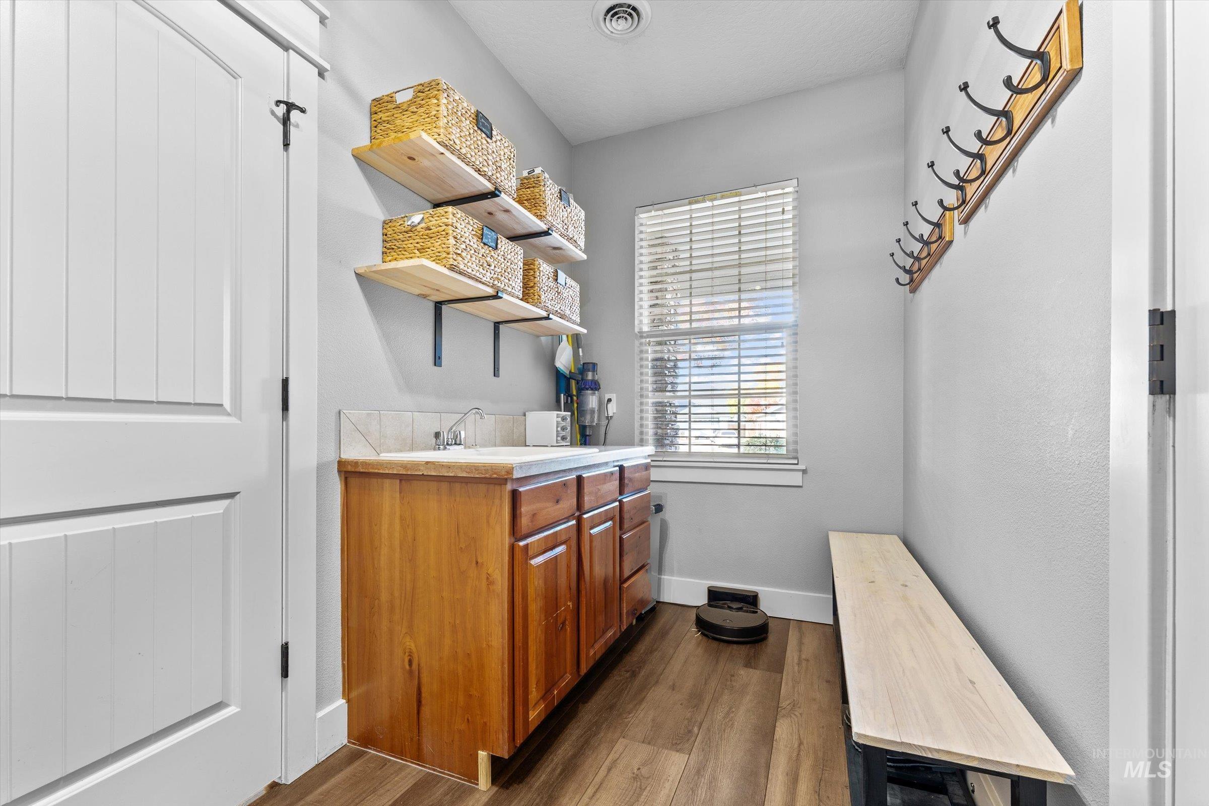 Laundry area with dark wood finished floors and baseboards