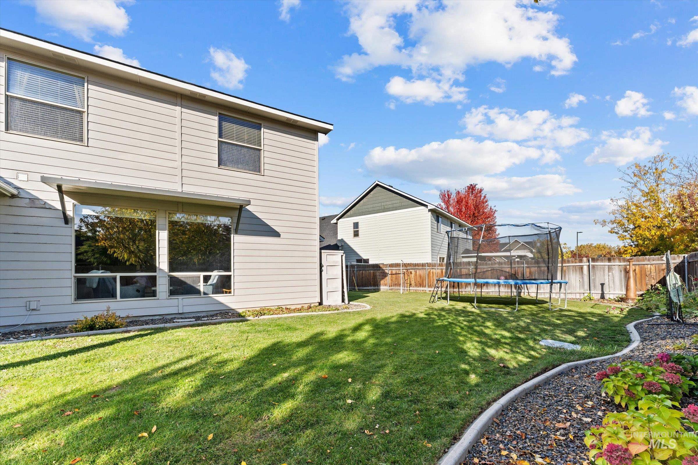 Fenced backyard with a trampoline