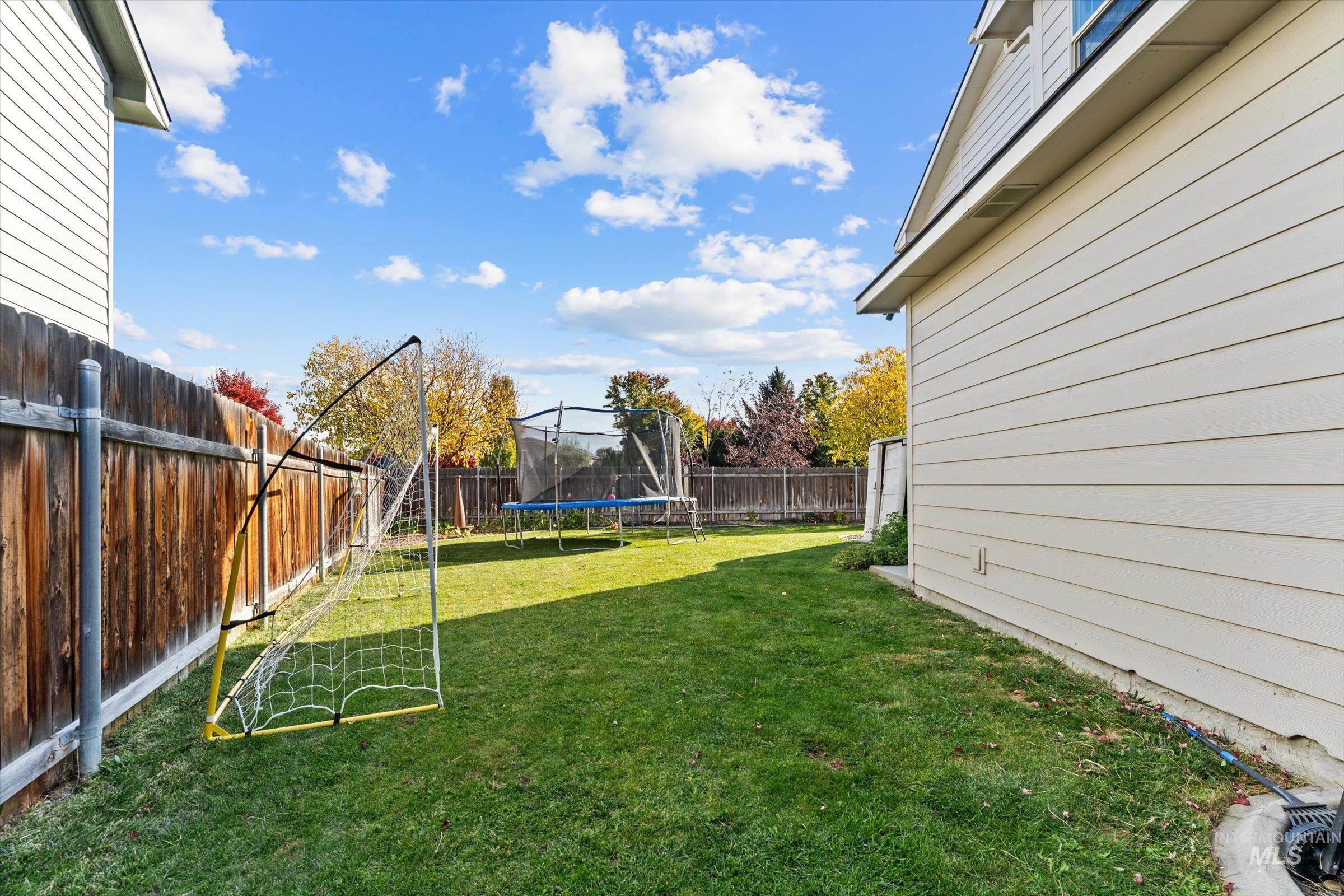 Fenced backyard with a trampoline