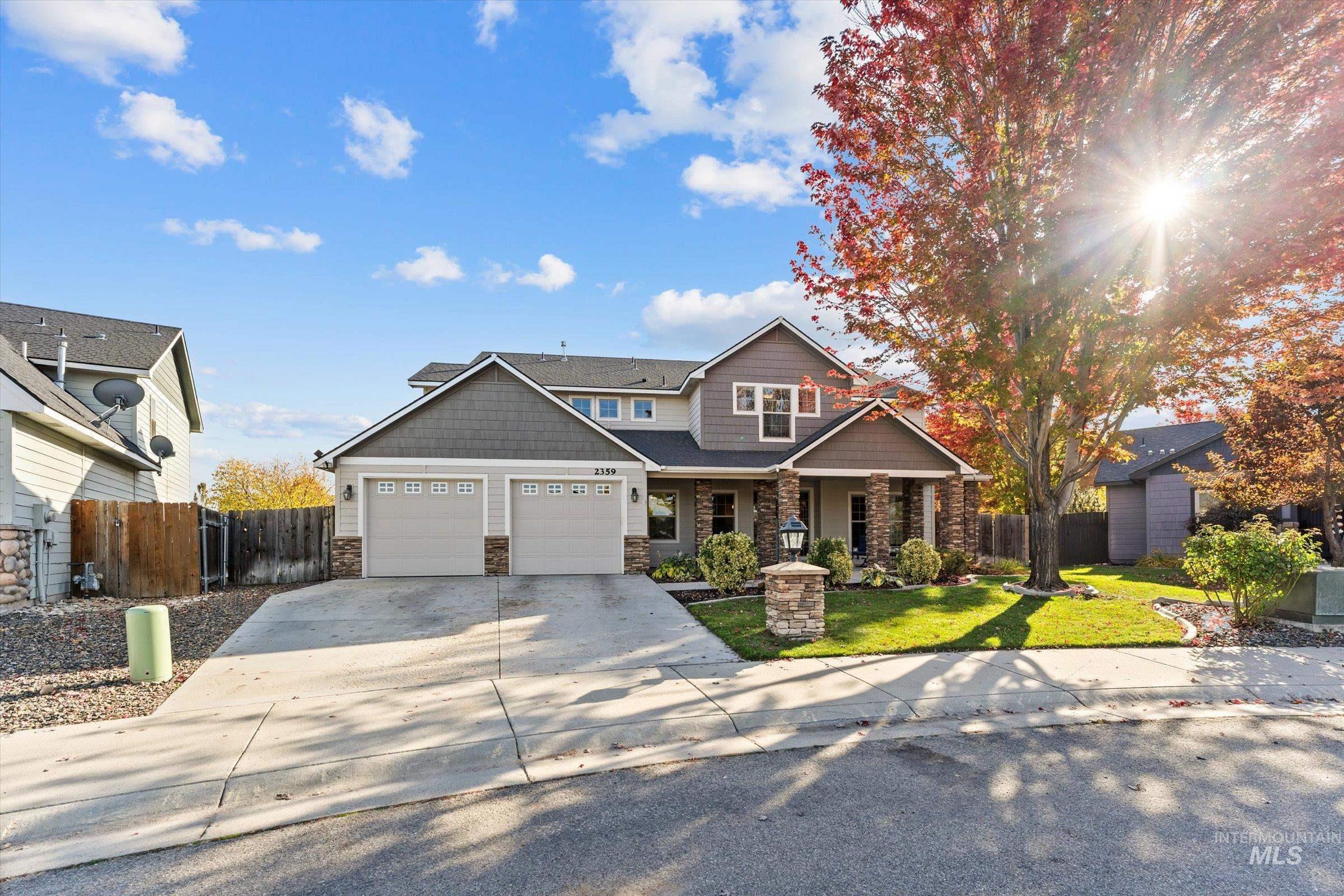 Craftsman-style home with stone siding, driveway, a porch, and an attached garage
