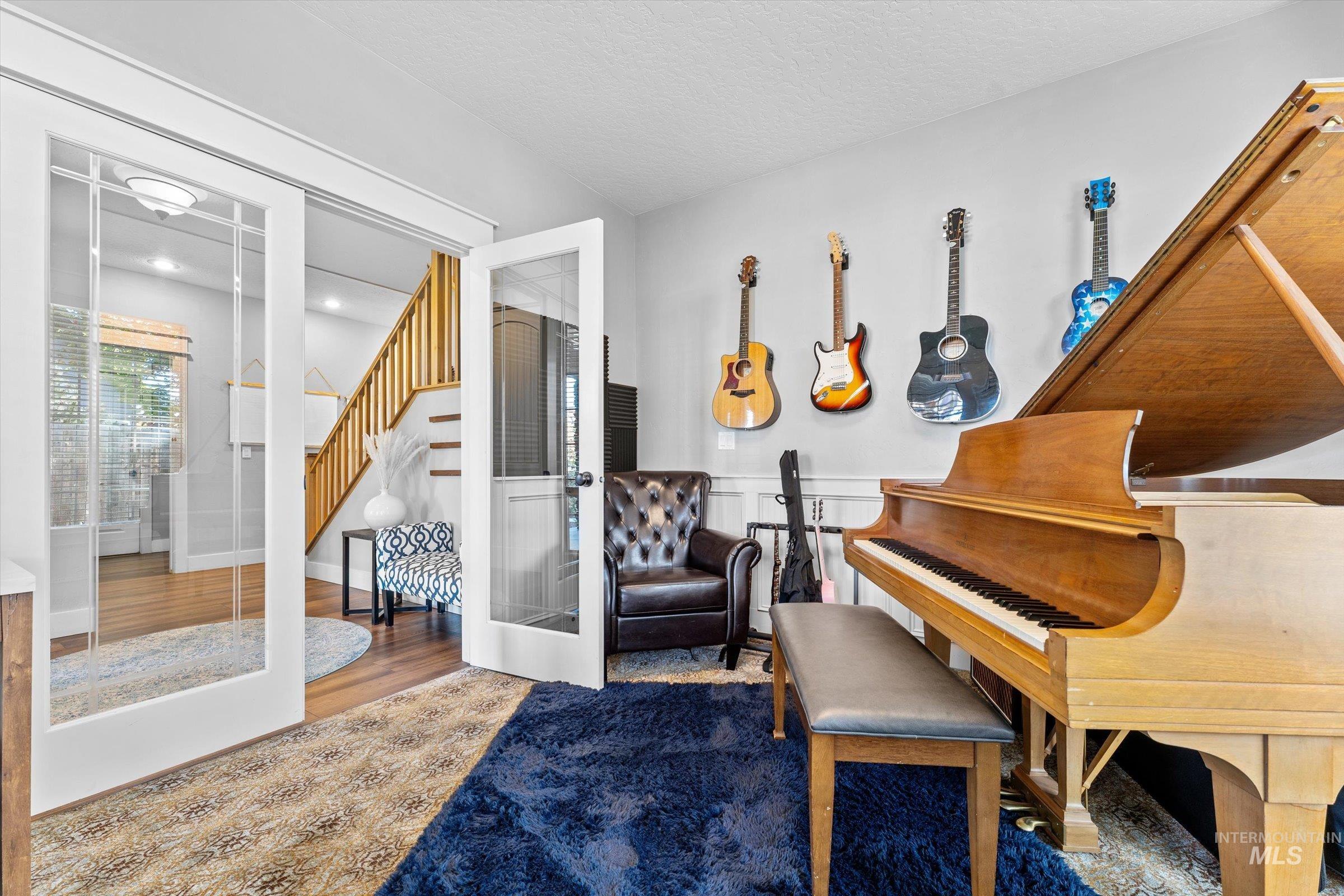 Living area featuring wood finished floors, stairs, and french doors