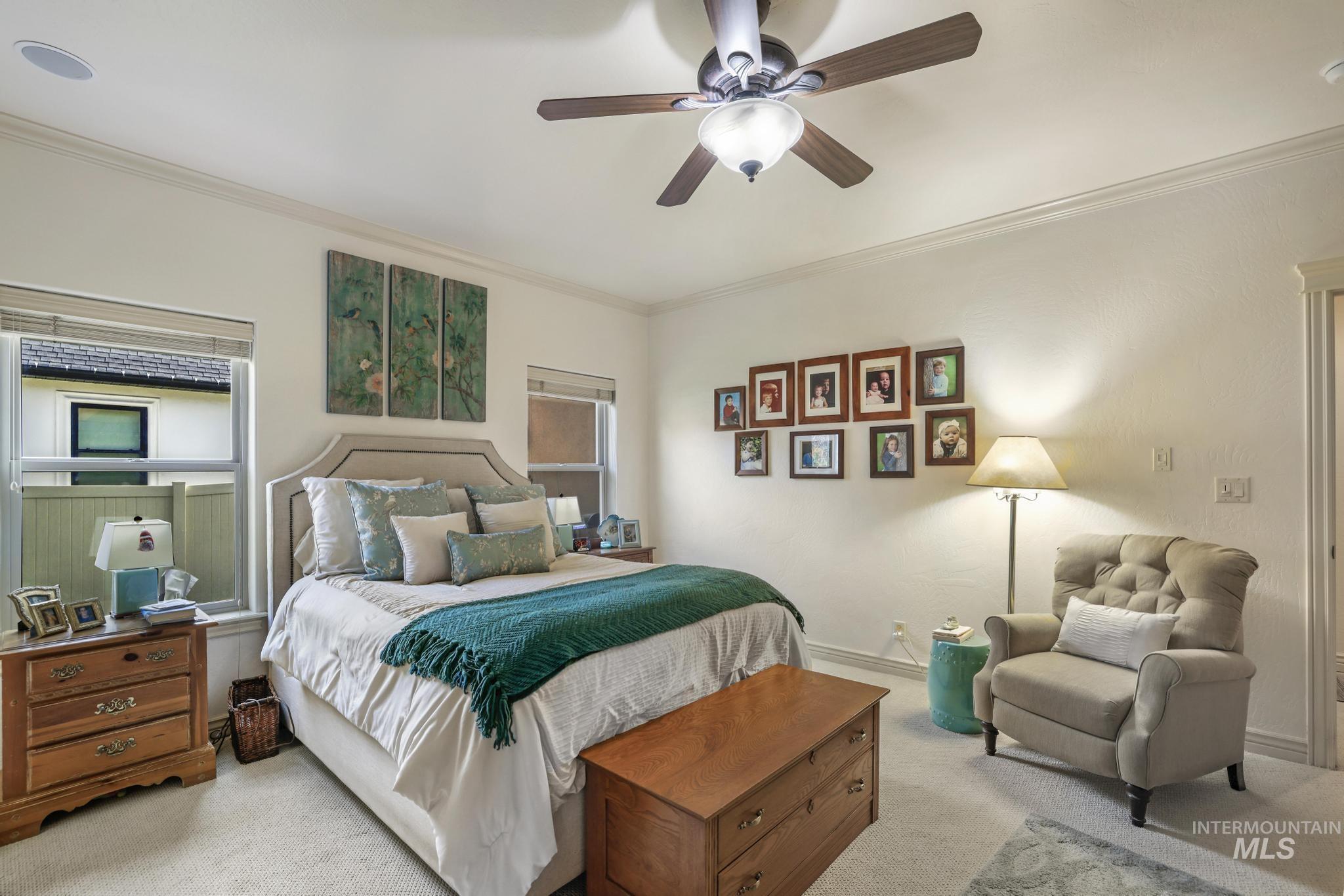 Bedroom featuring carpet flooring, ornamental molding, and a ceiling fan