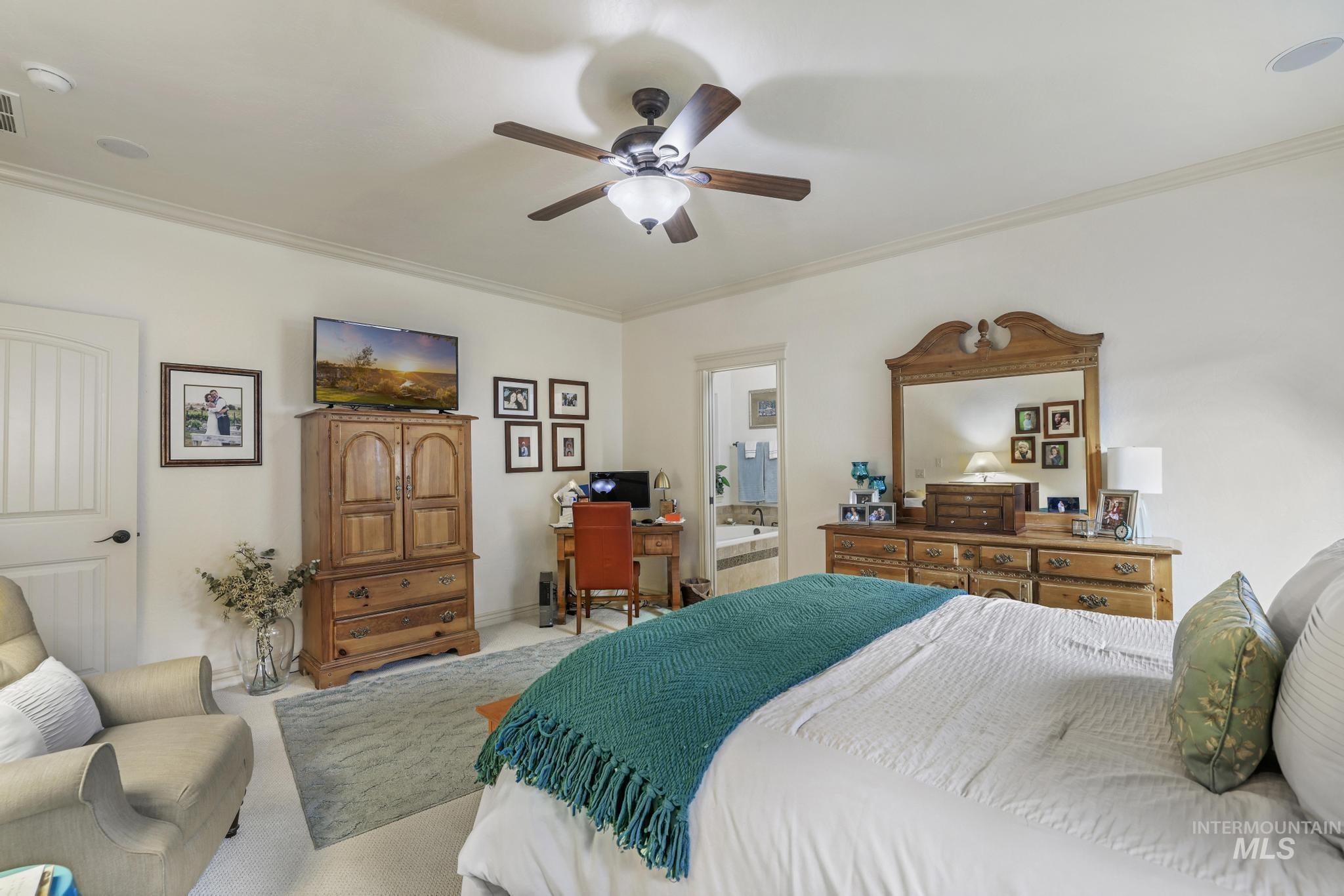 Bedroom with ornamental molding, carpet floors, a ceiling fan, ensuite bathroom, and an office area