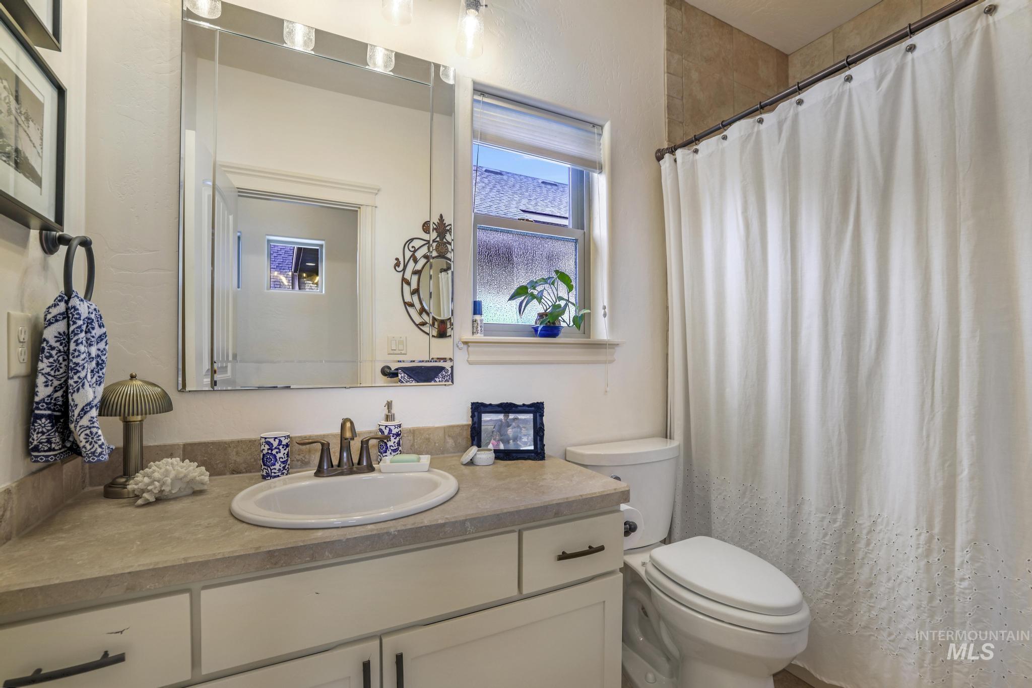 Bathroom with a shower with shower curtain and vanity