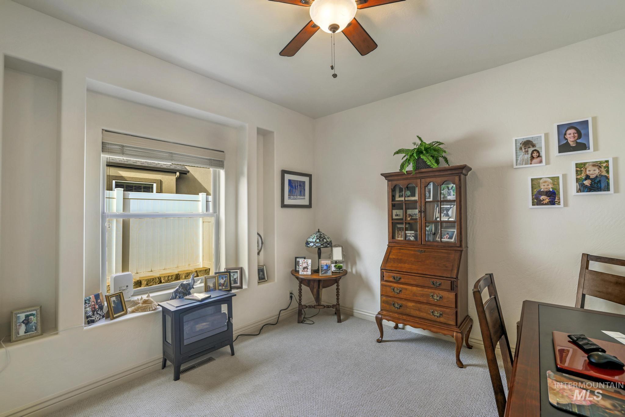 Living area with carpet floors and ceiling fan
