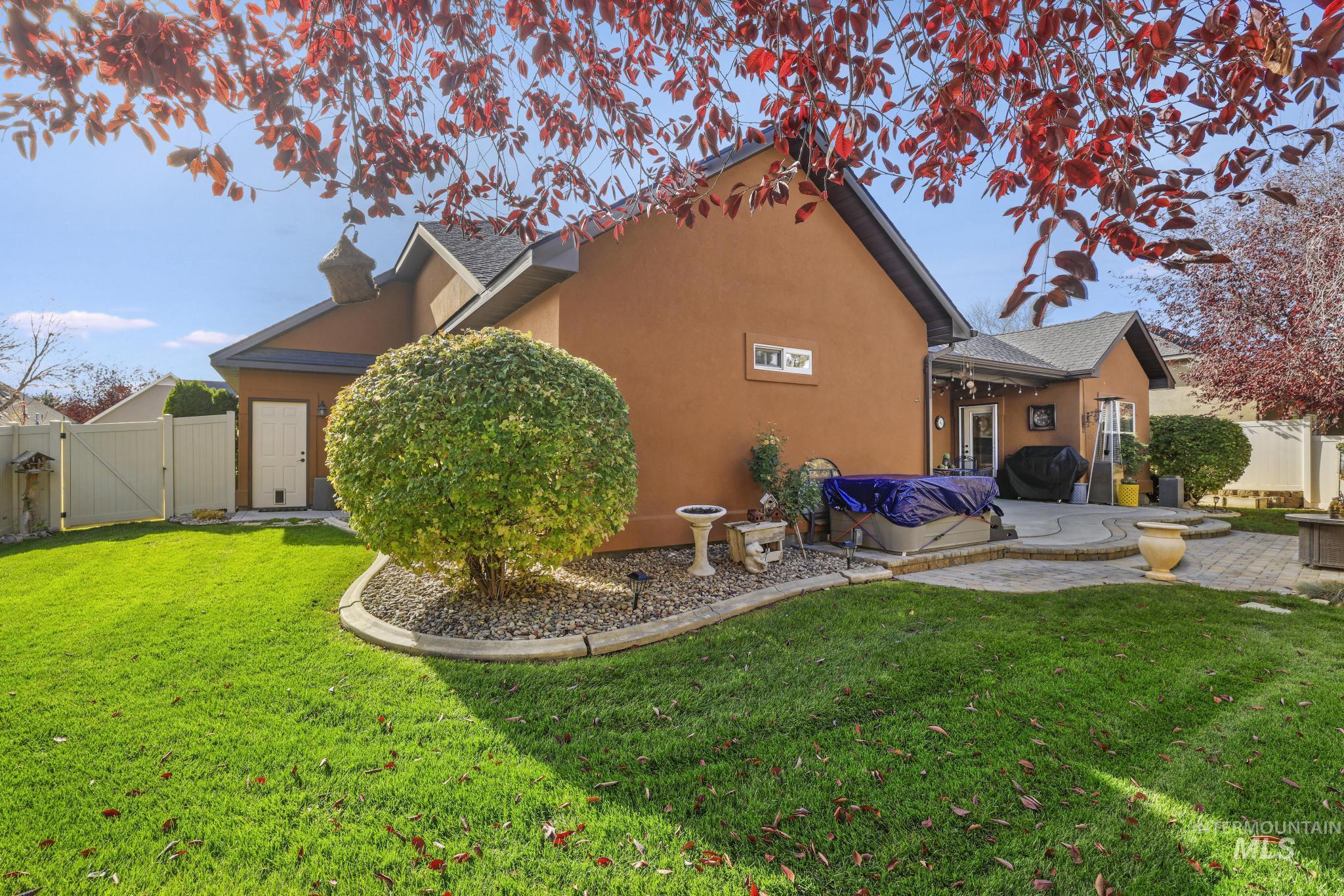 Rear view of house featuring a gate, stucco siding, and a patio