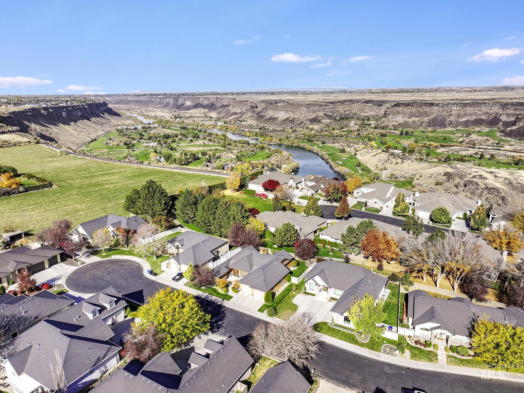 Aerial view of property and surrounding area with a large body of water and nearby suburban area