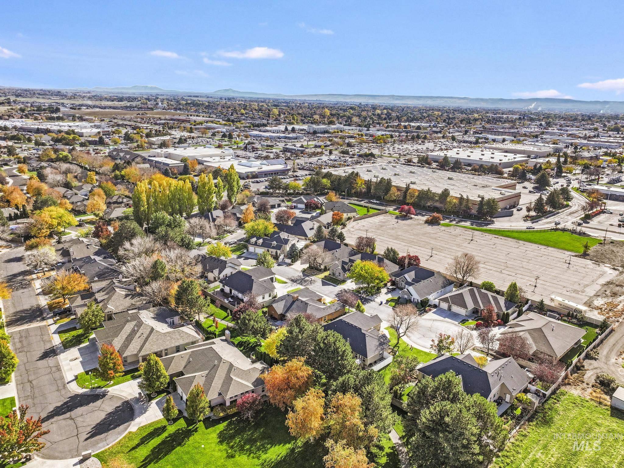 Aerial view of property and surrounding area featuring nearby suburban area and mountains