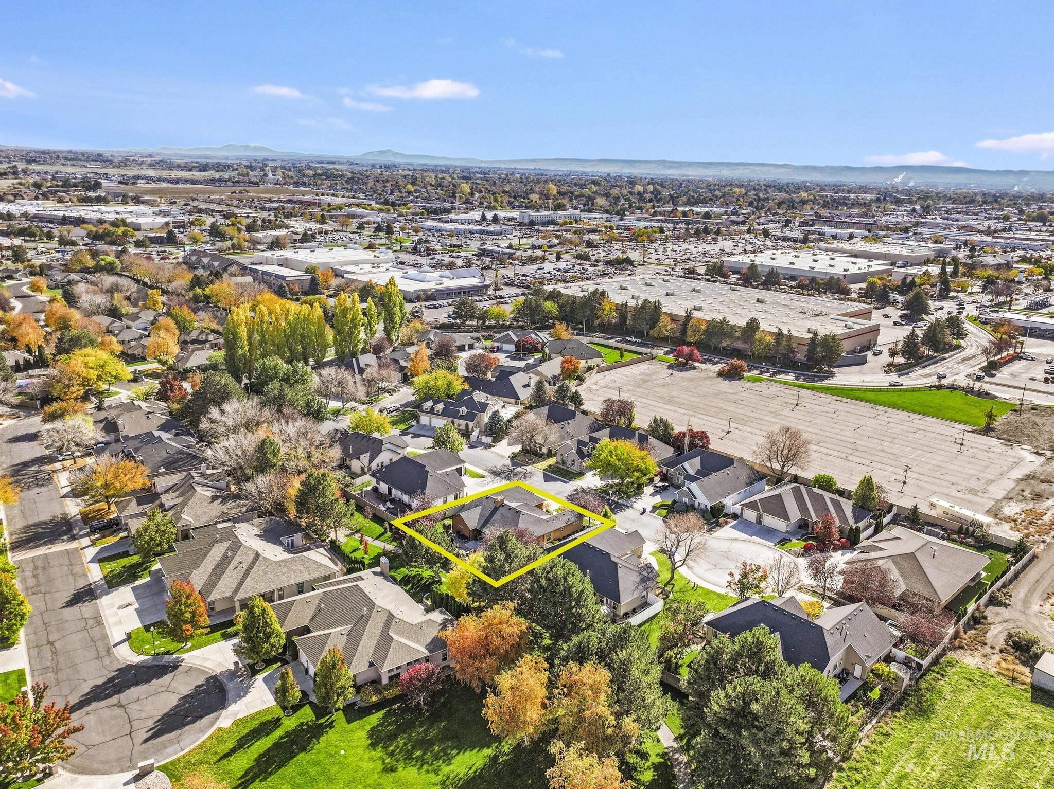 Aerial view of property and surrounding area featuring property boundaries highlighted and a mountain backdrop